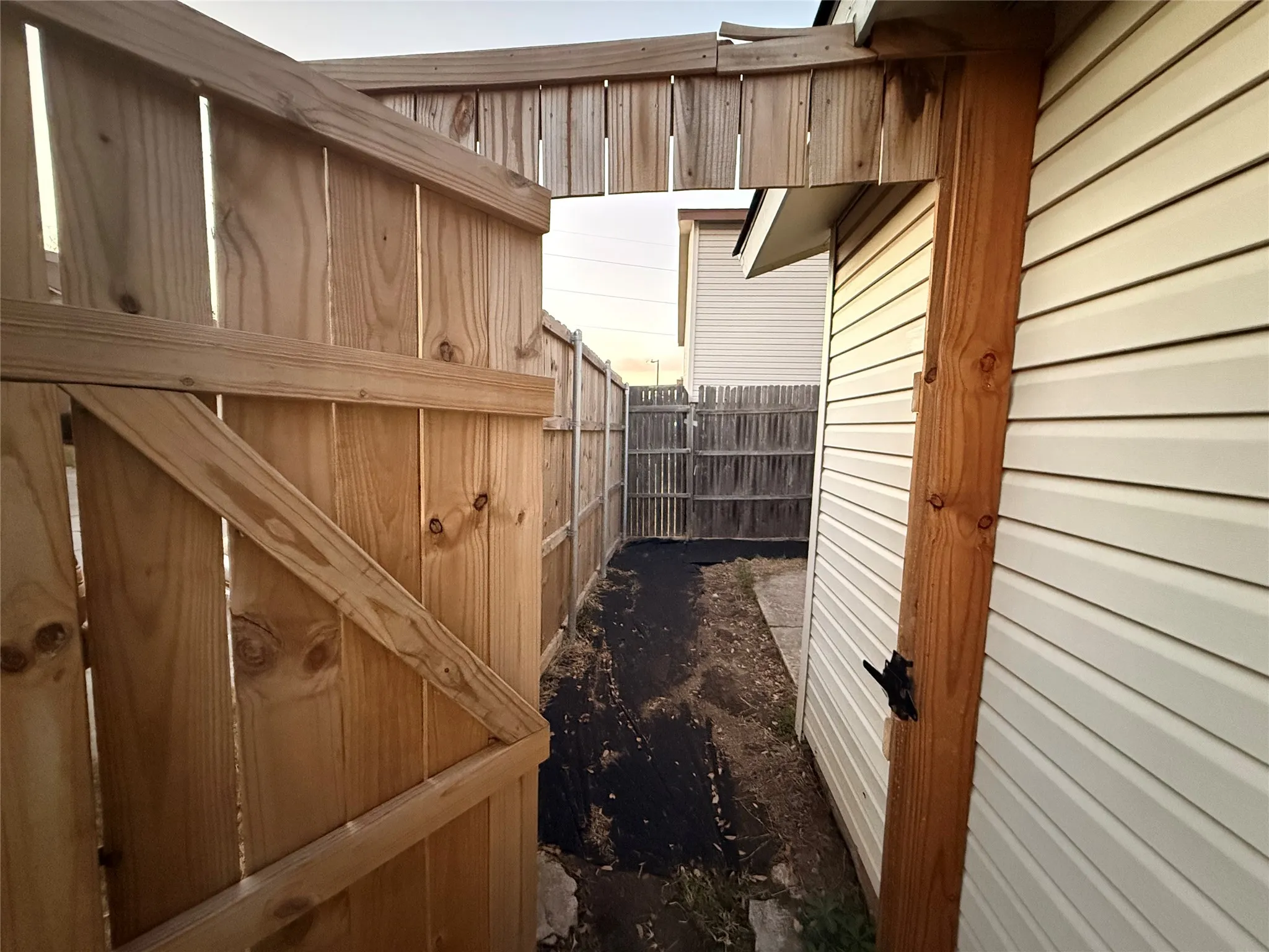 New wood fence with a functional gate, providing access to the side yard