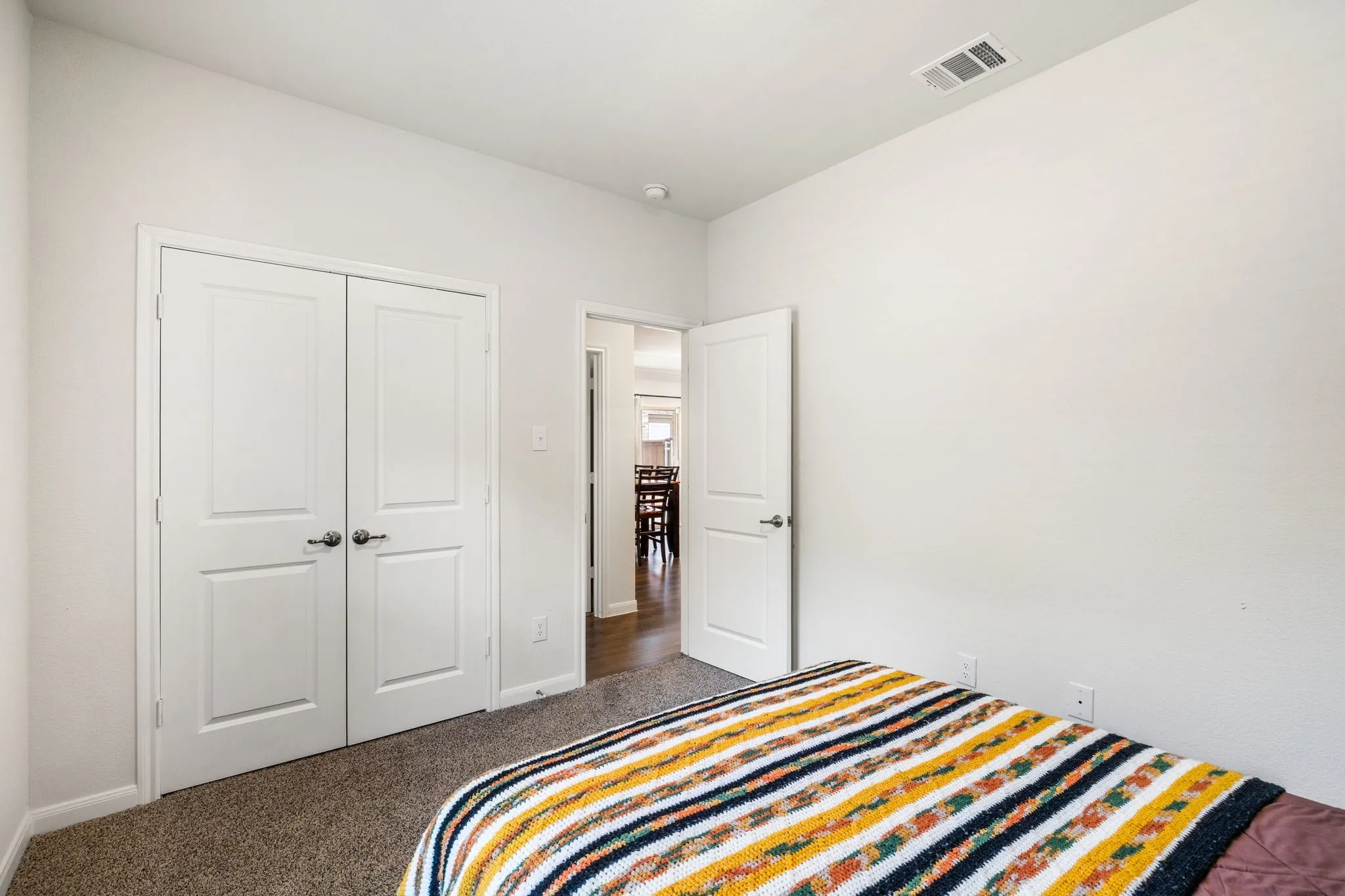 Bedroom #2 featuring carpet flooring, white wall finishes, and large window letting in natural light.