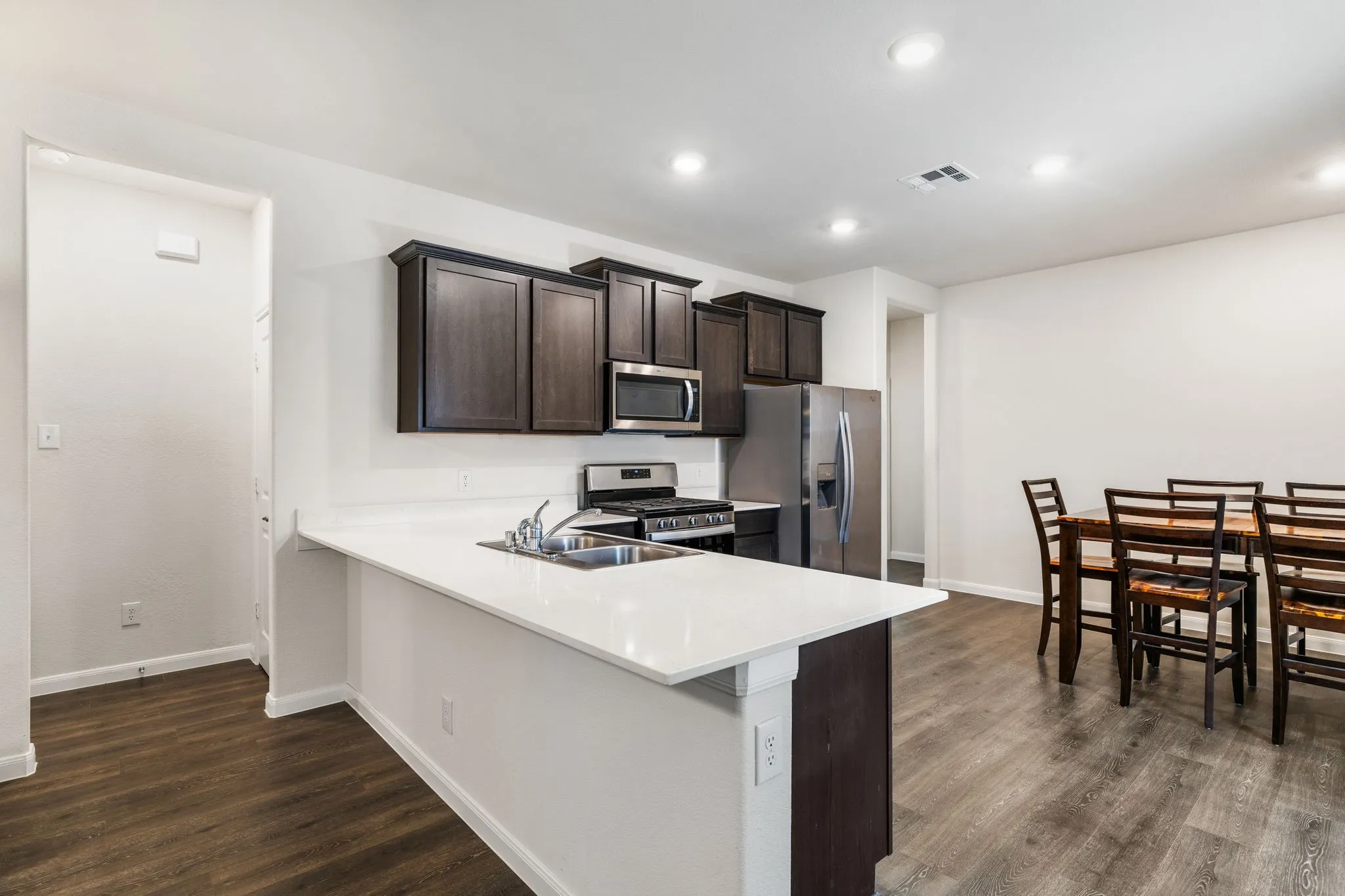 Kitchen and dining area featuring a peninsula counter top and breakfast bar, with plenty of room for dining table large enough to seat you and your family and friends.
