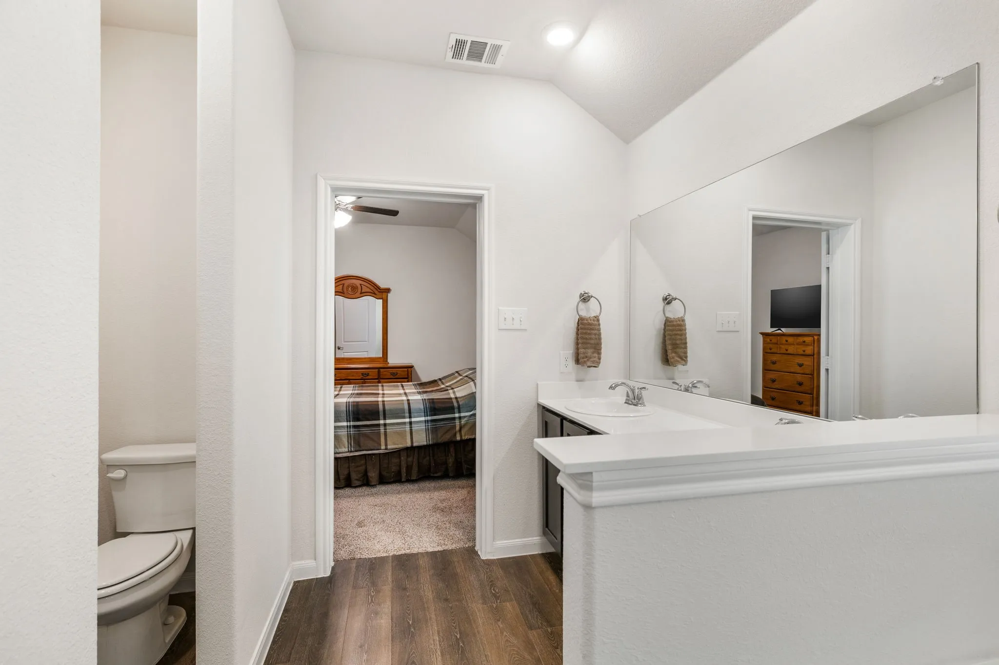 Primary bathroom features a separate stall shower and garden tub, double vanity, lofted ceiling, luxury vinyl plank flooring, and walk-in closet.