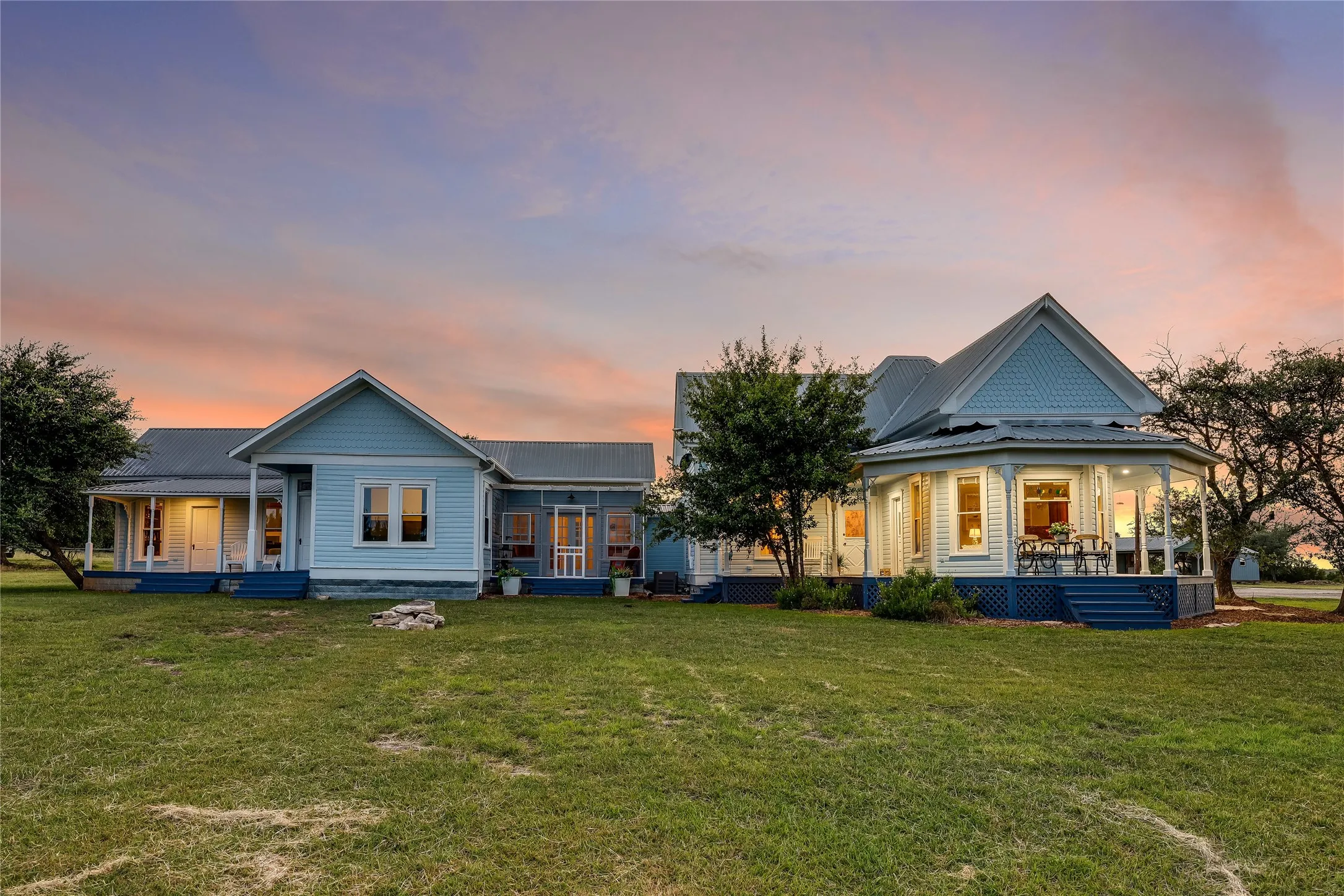 Expansive property featuring two distinct structures with light blue siding and dark blue trim