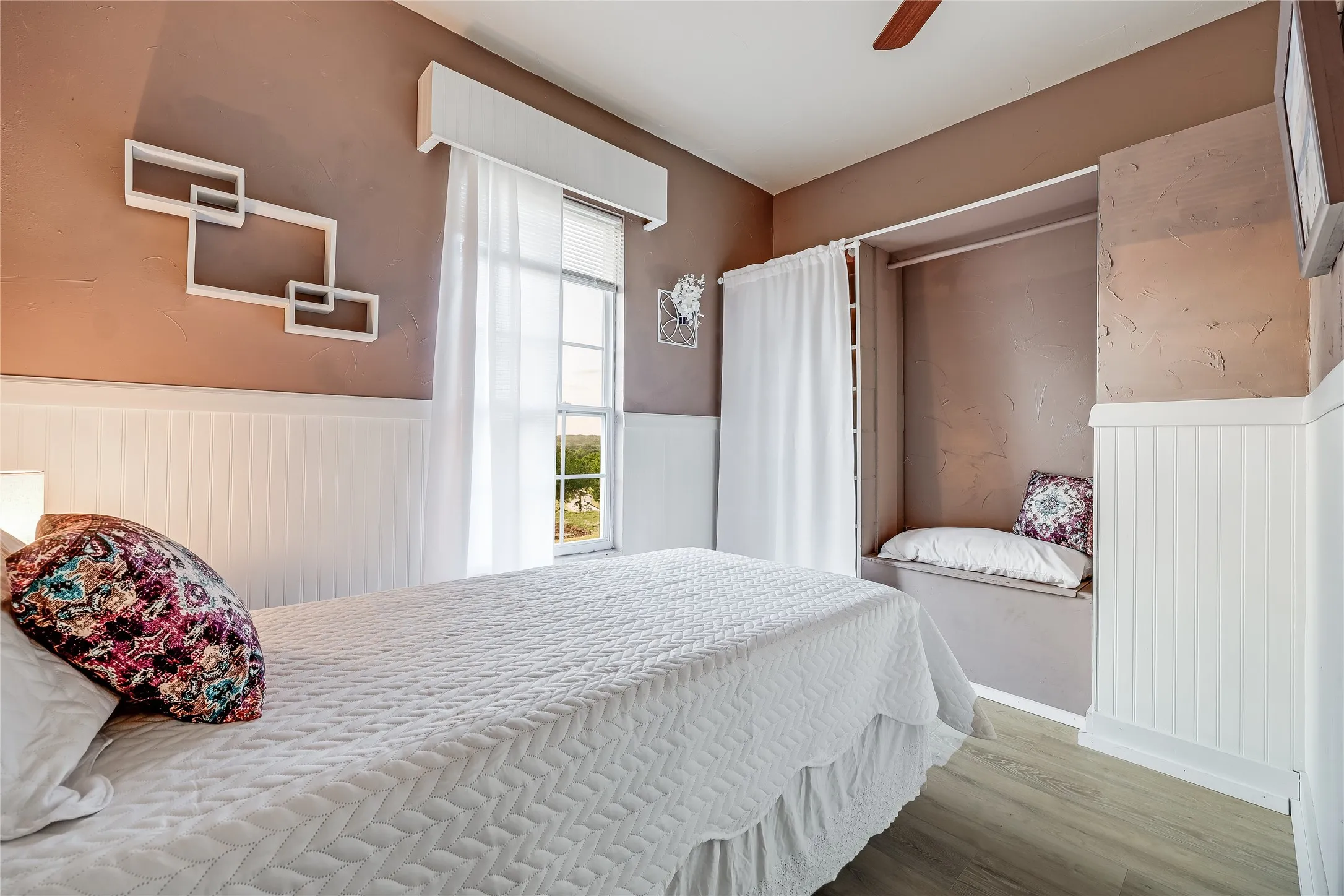 Interior room featuring beadboard wainscoting, neutral tone walls, and wood-finish flooring