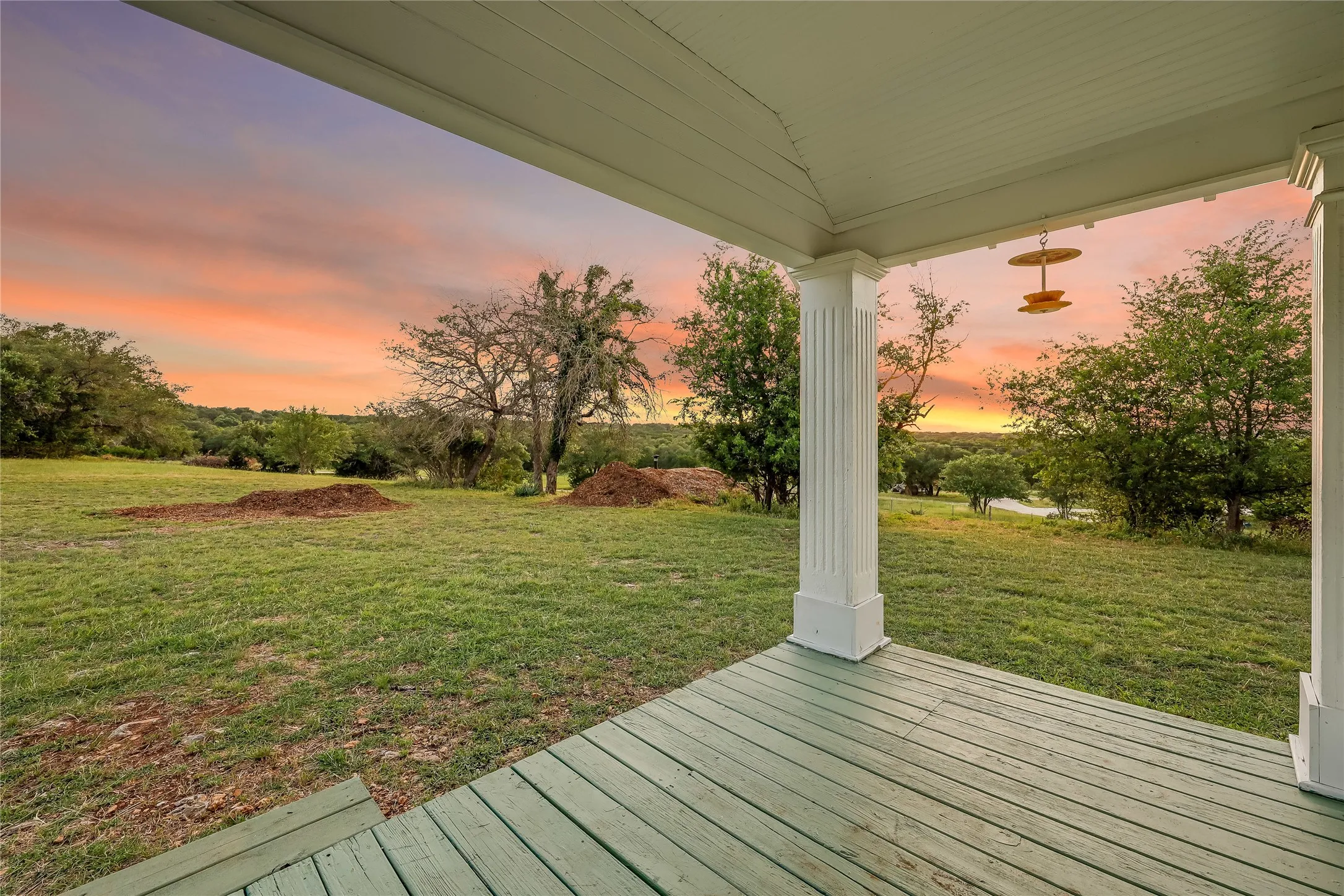 Covered porch with wood-finish flooring and classical columns