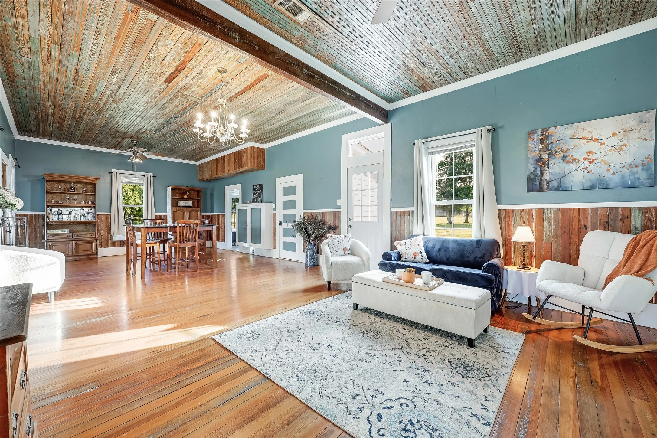 Spacious room featuring wood-finish flooring, a corrugated wood-panel ceiling, and exposed wood beams