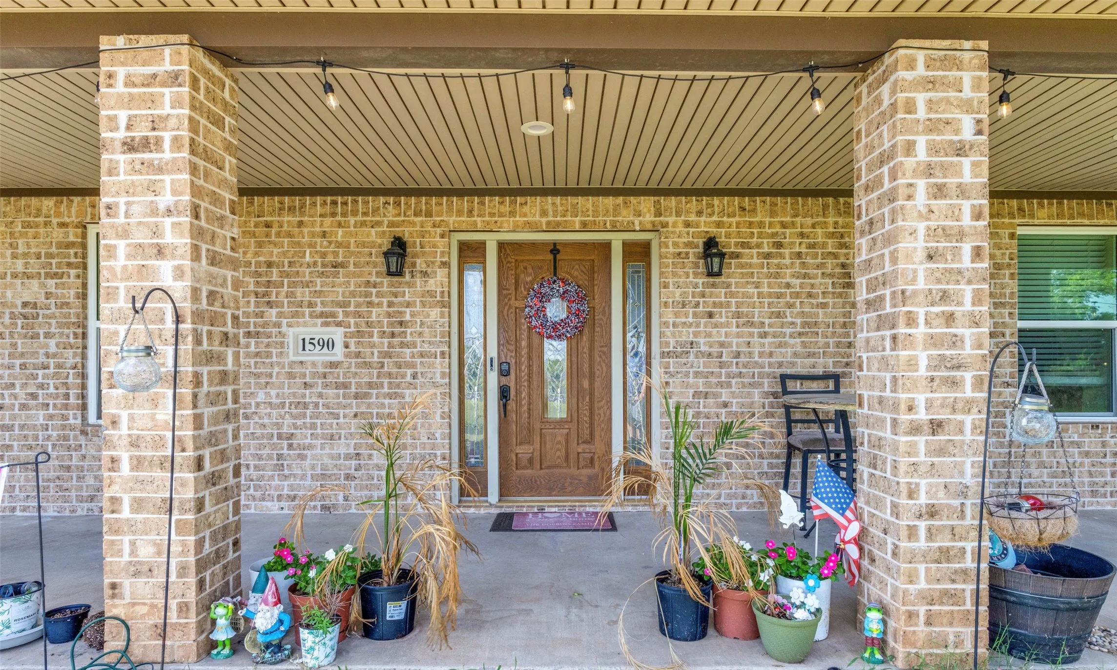 Doorway to property with covered porch and brick siding