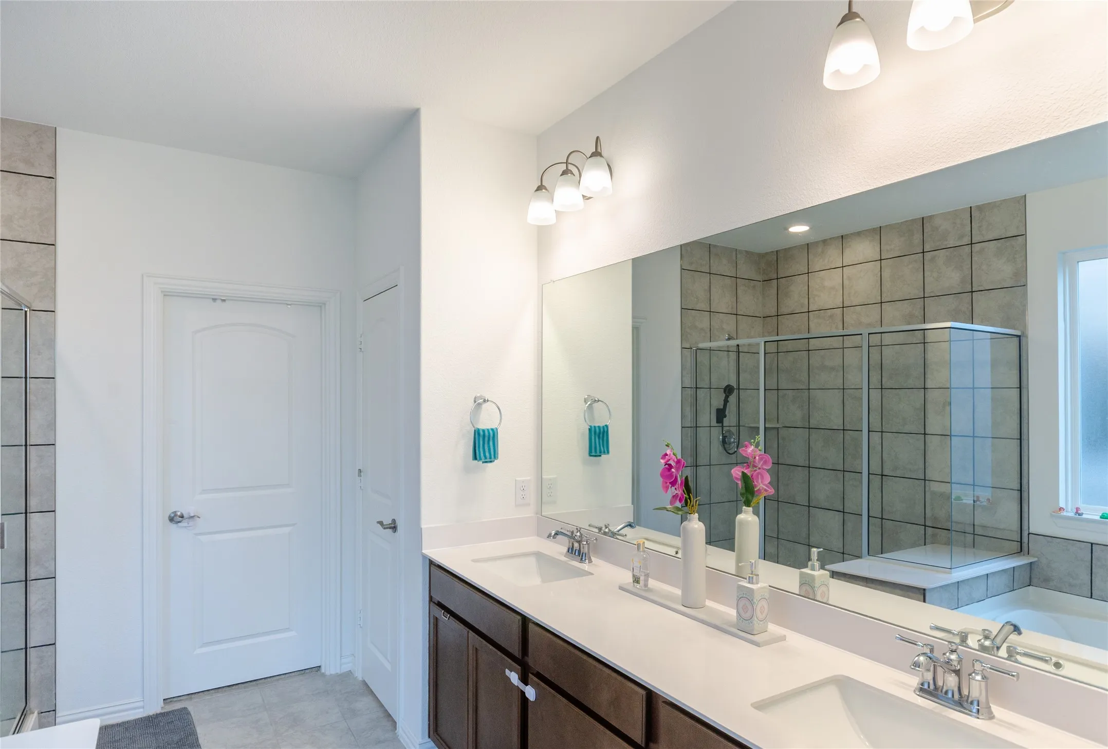 Double vanity with undermount sinks, chrome fixtures, and dark wood-finish cabinetry