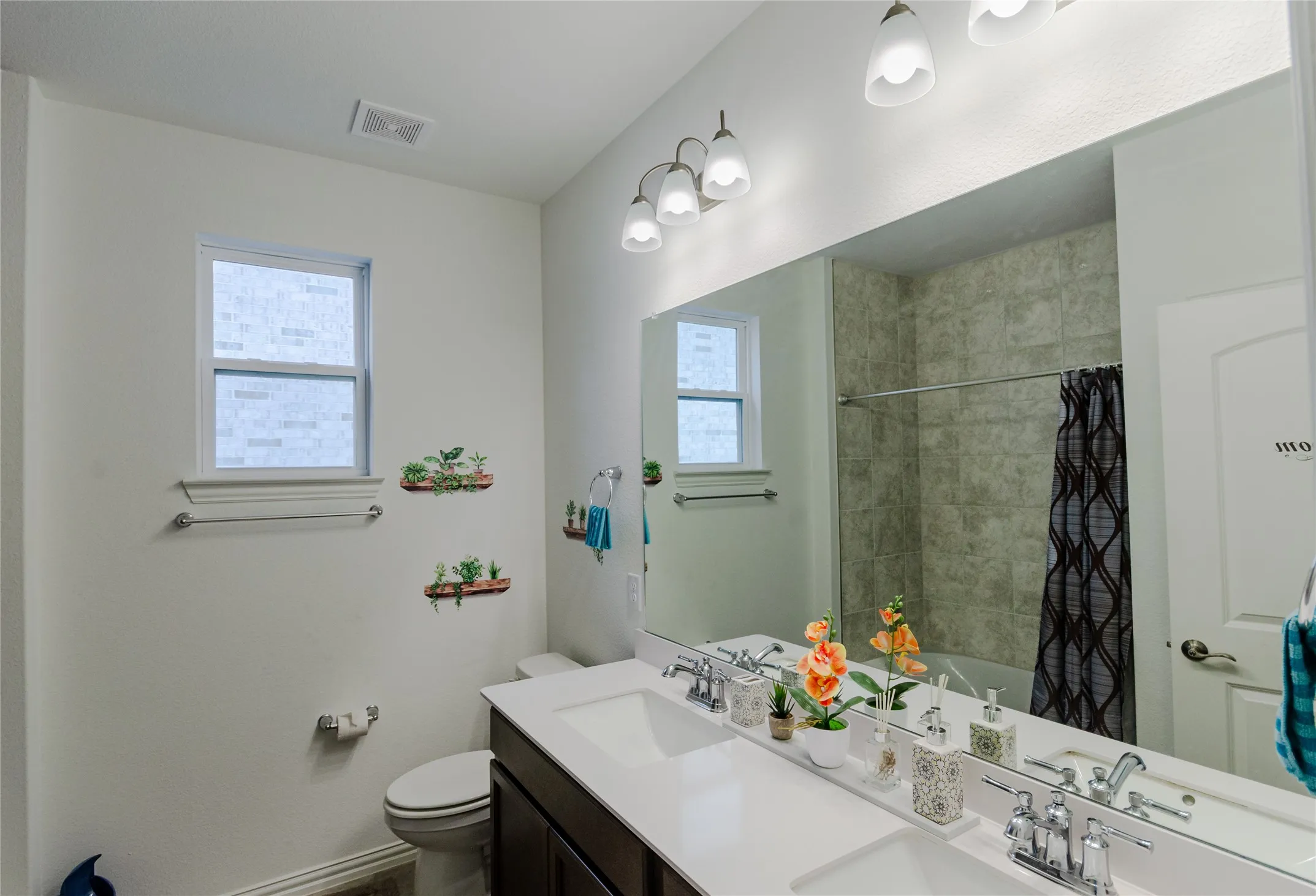 Dual vanity with white countertops, chrome fixtures, and dark wood-finish cabinetry