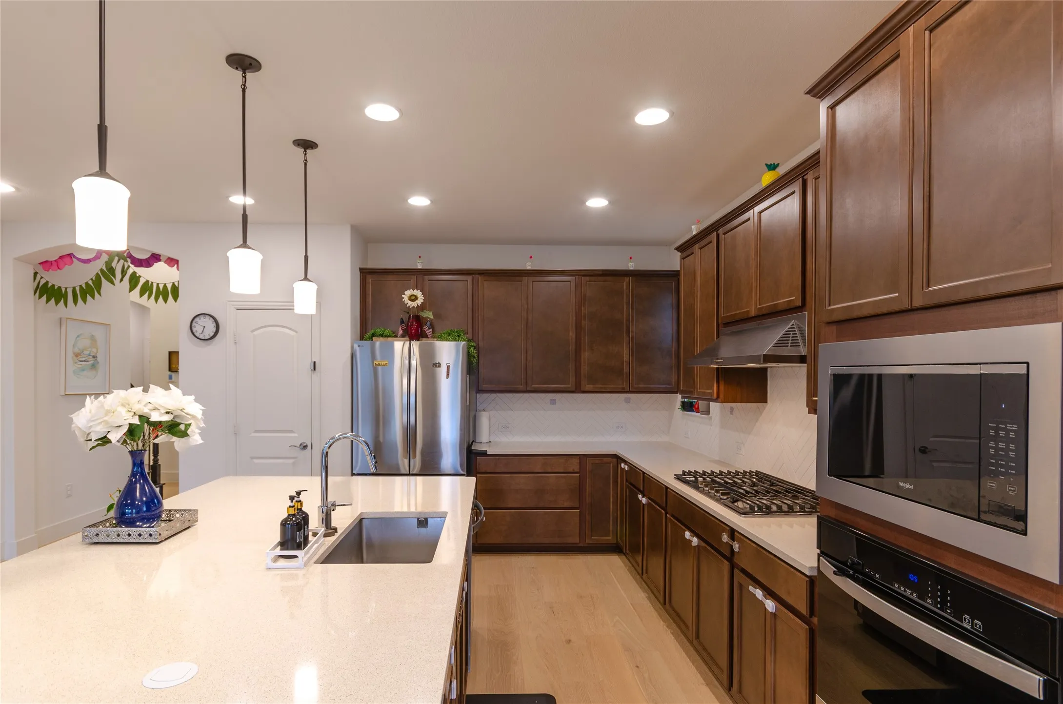 Kitchen featuring an expansive island with an undermount sink, pendant lighting, and recessed ceiling lights