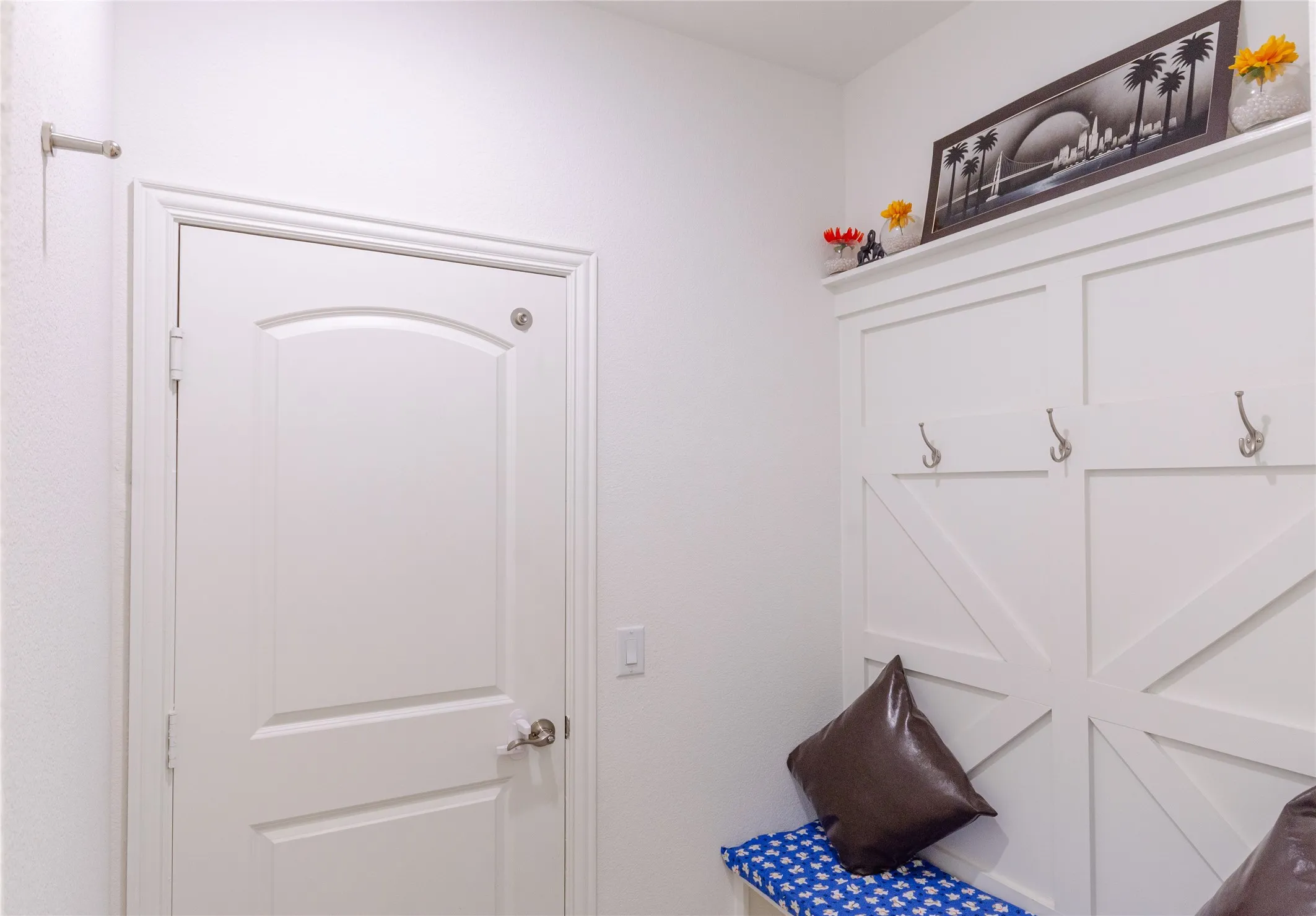 White panel door with arched top panel, contrasting with a white board and batten wall feature