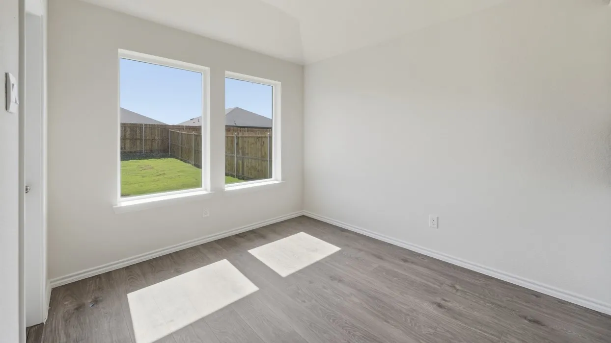 Room featuring two large windows, wood-finish flooring, white baseboards, and neutral wall tones