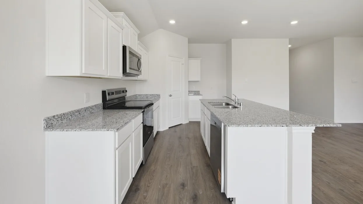 Bright kitchen featuring white cabinetry, speckled countertops, stainless steel appliances, and wood-finish flooring