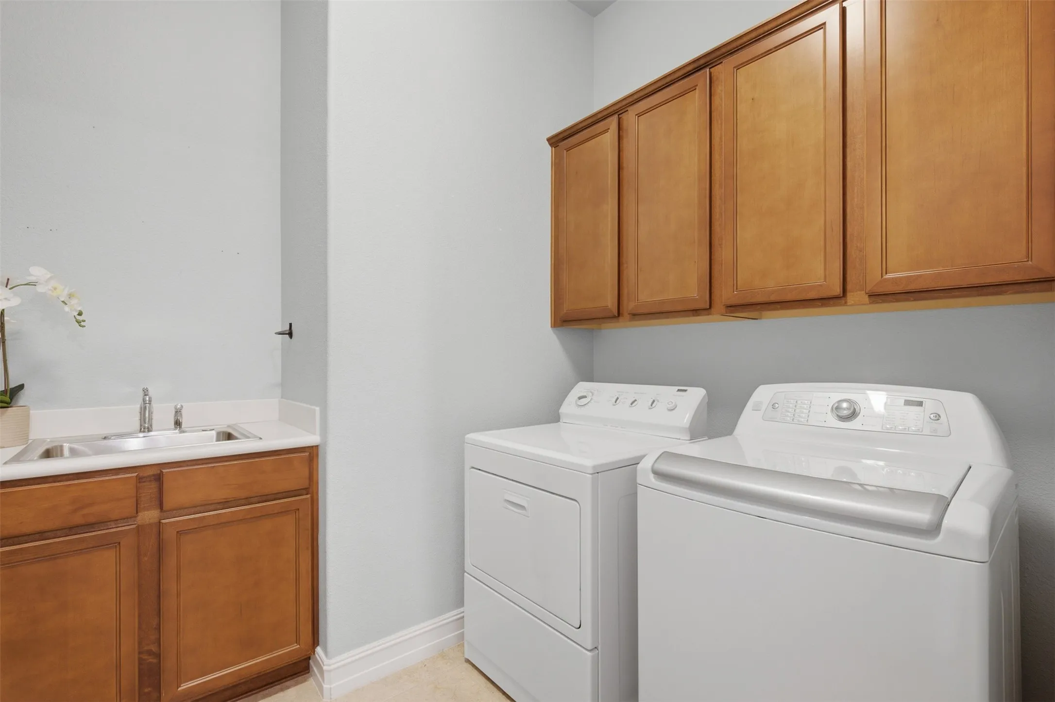 Spacious first-floor laundry room with built-in storage, workspace, and utility sink.