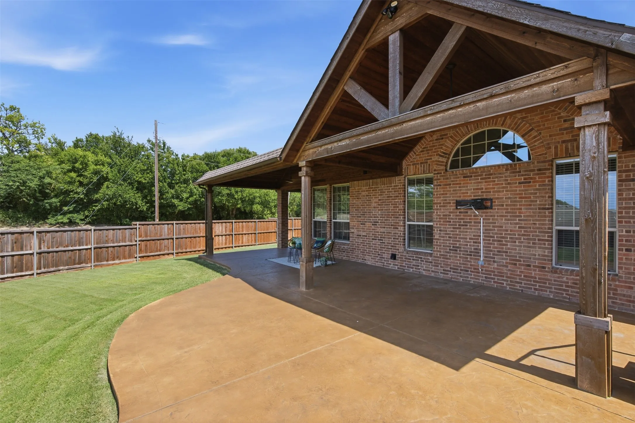 Vaulted covered patio creating a comfortable outdoor living and entertaining space overlooking the backyard.