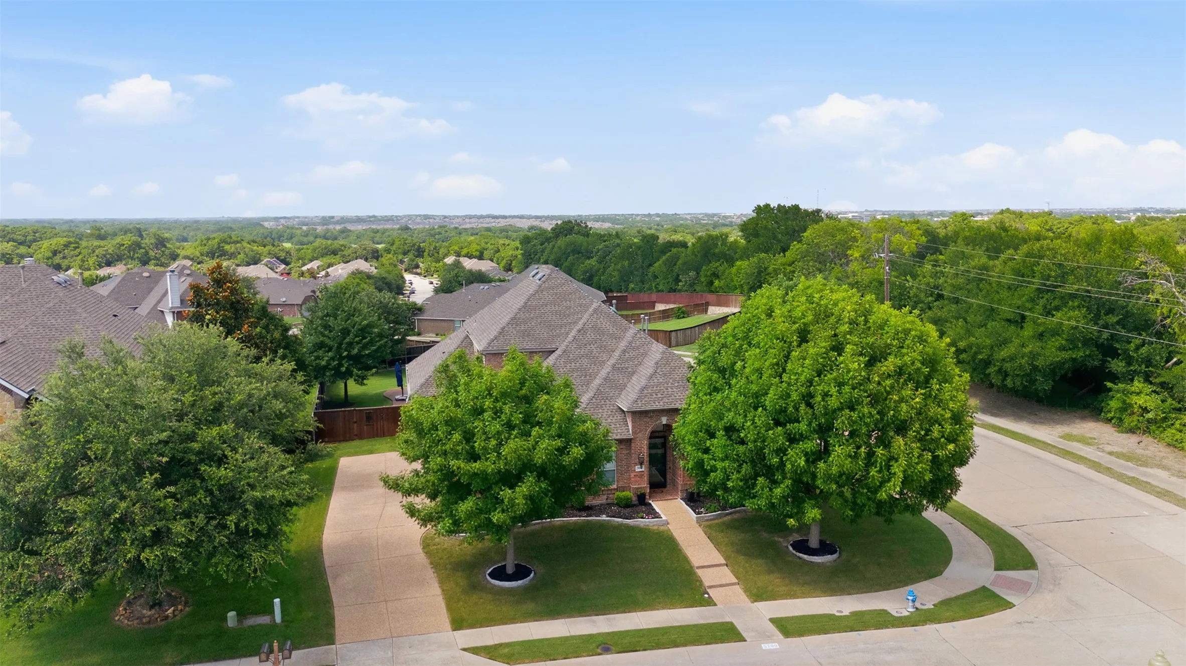 Beautiful brick and stone exterior with mature landscaping in the Cambridge neighborhood of McKinney, Texas.