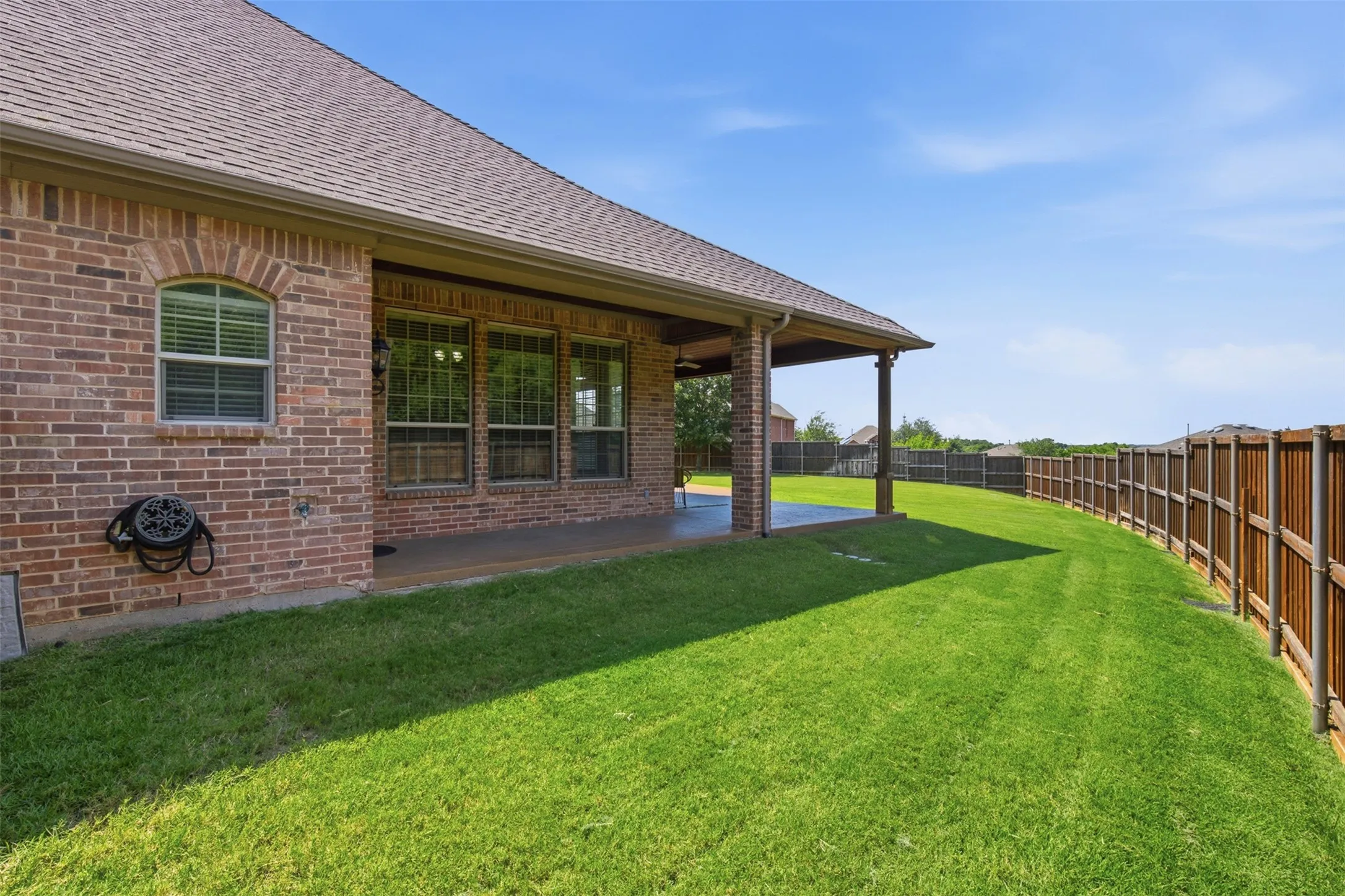 Inviting view of the covered patio and resort-style backyard at 5700 Waterford Lane.