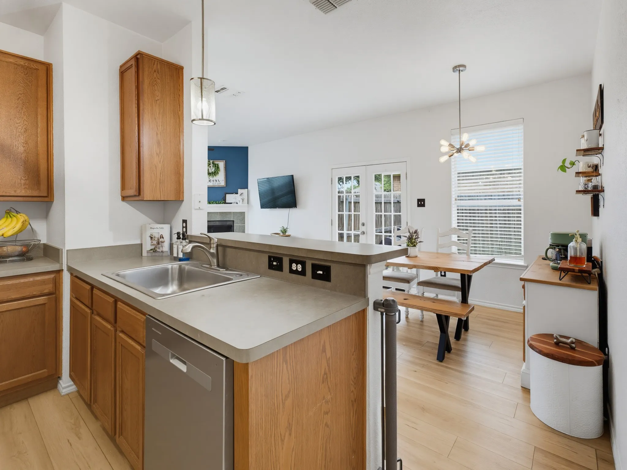 Kitchen featuring wood-finish cabinetry, a stainless steel sink, and light-toned countertops