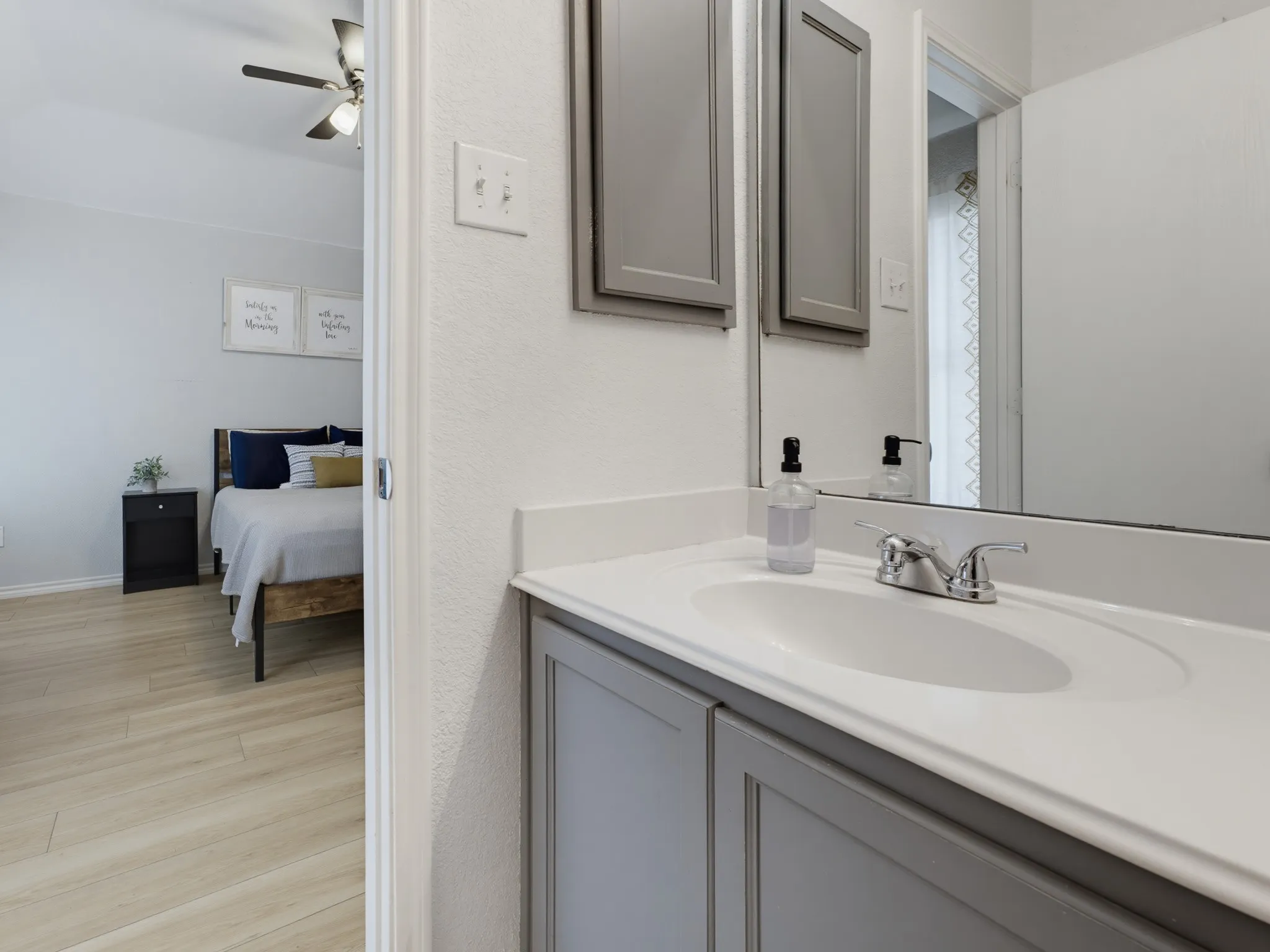Bathroom vanity featuring a white countertop with an integrated sink and chrome faucet