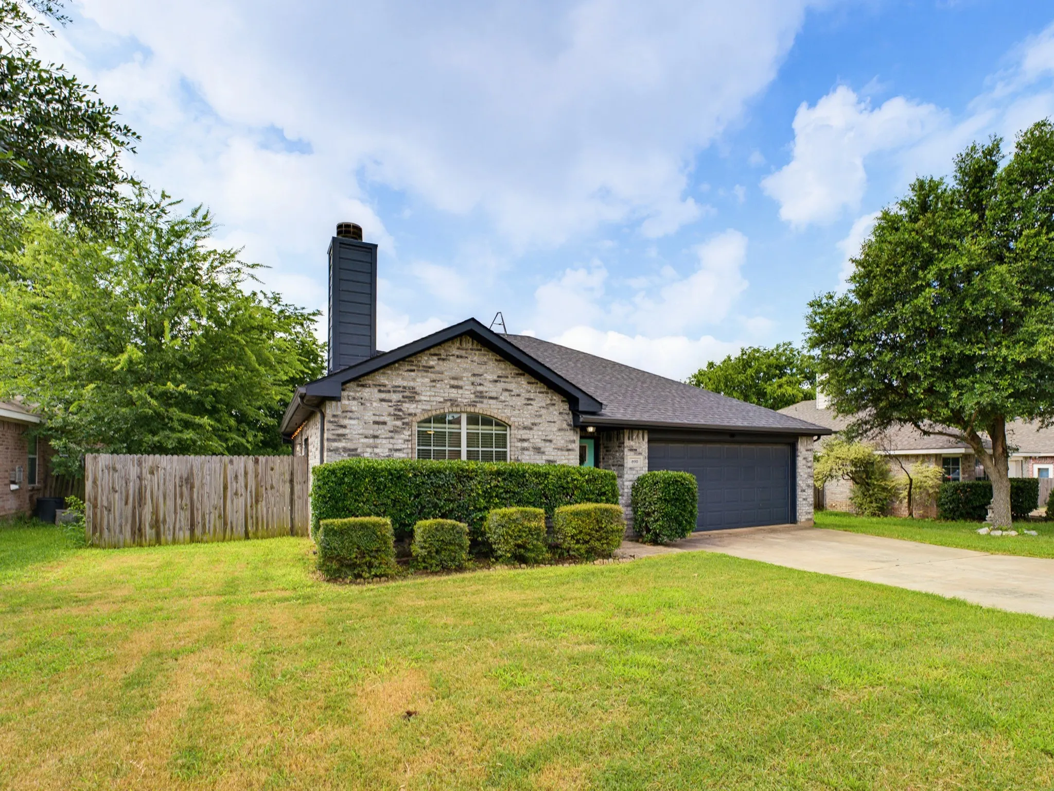 Single-story residence featuring a brick exterior with dark trim and a dark composition shingle roof