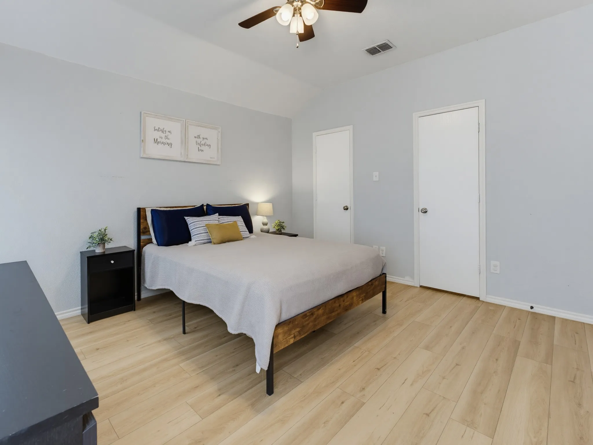 Bedroom featuring light wood-finish flooring, light gray walls, and a vaulted ceiling