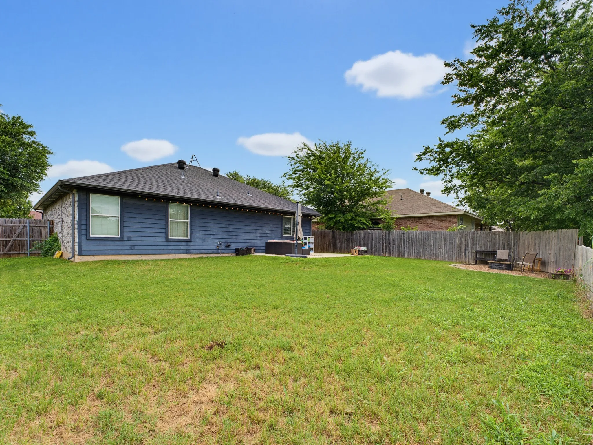 Expansive green lawn with a privacy fence