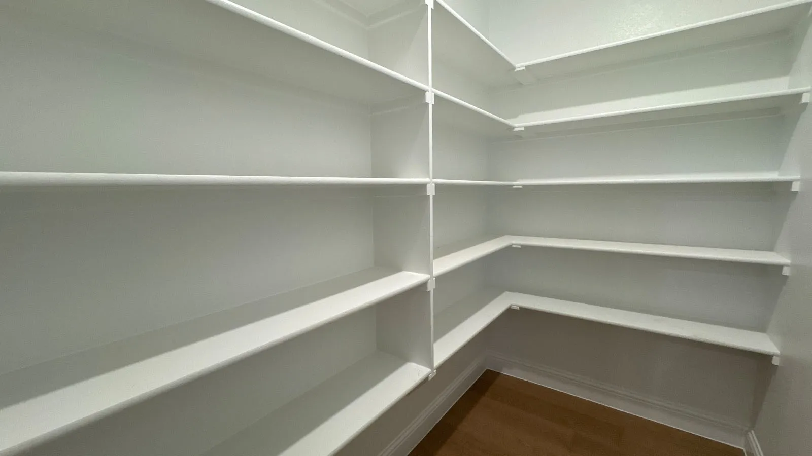 White built-in shelving with ample storage, featuring durable wood-finish flooring
