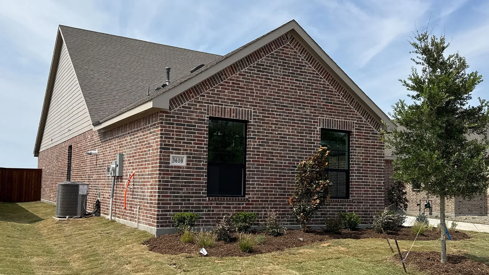 Brick exterior with dark window frames, gabled roof, and light siding accents