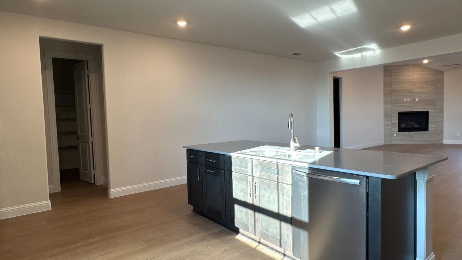 Kitchen island with integrated sink, stainless steel dishwasher, and stone countertop