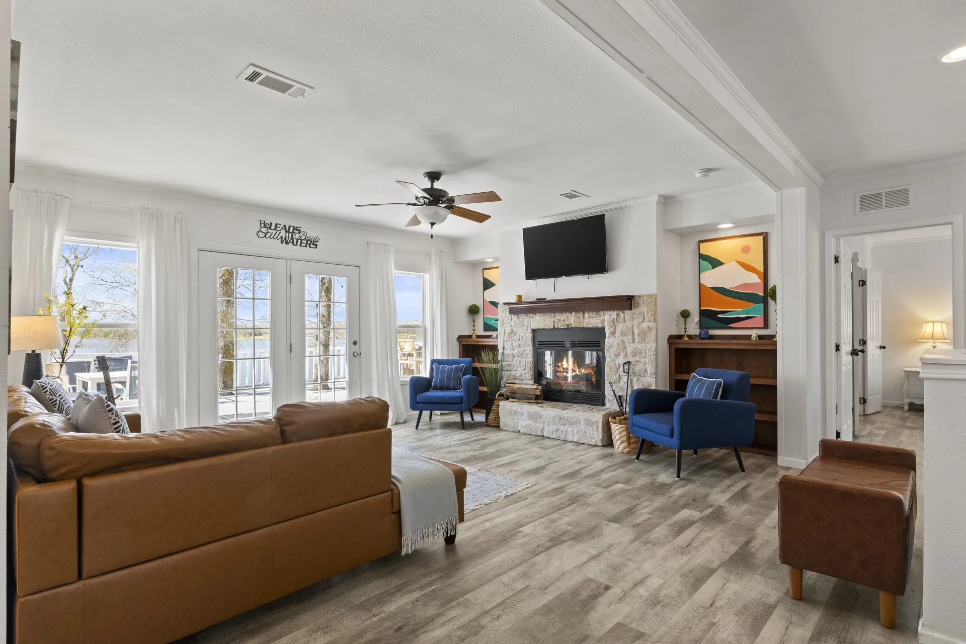 Living room featuring hardwood / wood-style flooring, a healthy amount of sunlight, ceiling fan, and a fireplace