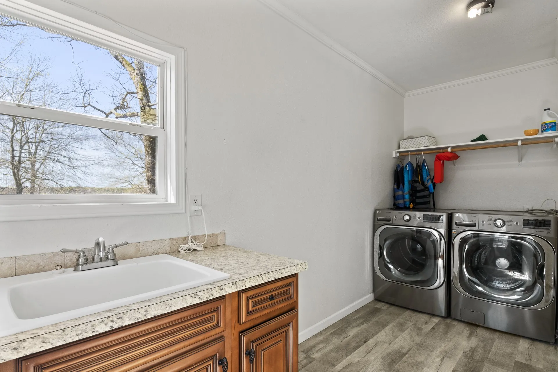 Clothes washing area with cabinets, washer and clothes dryer, sink, hardwood / wood-style floors, and crown molding