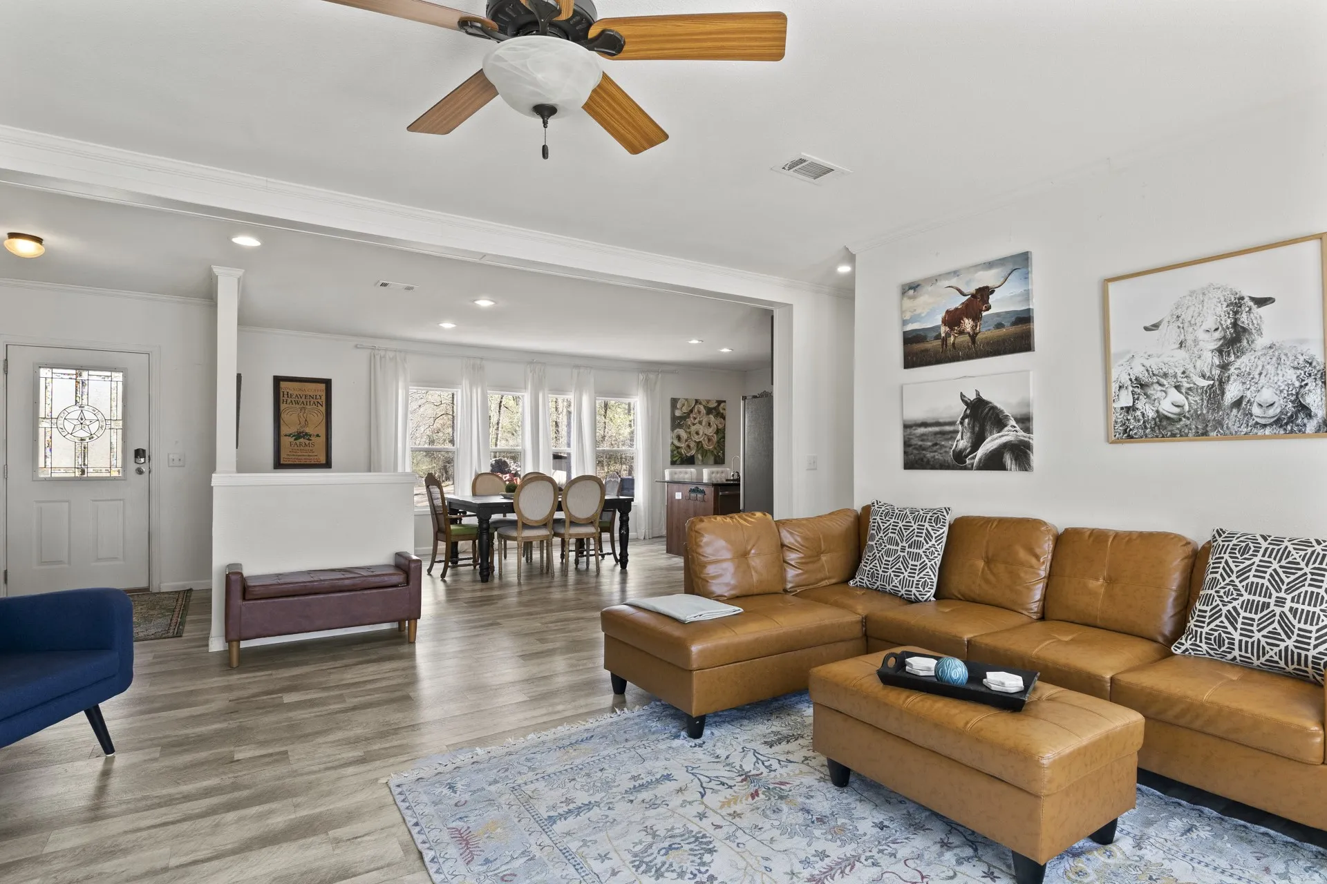 Living room with wood-type flooring, ceiling fan, and crown molding