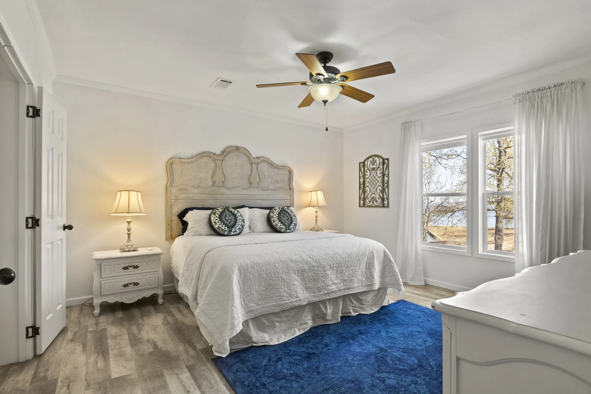 Bedroom with ornamental molding, wood-type flooring, and ceiling fan
