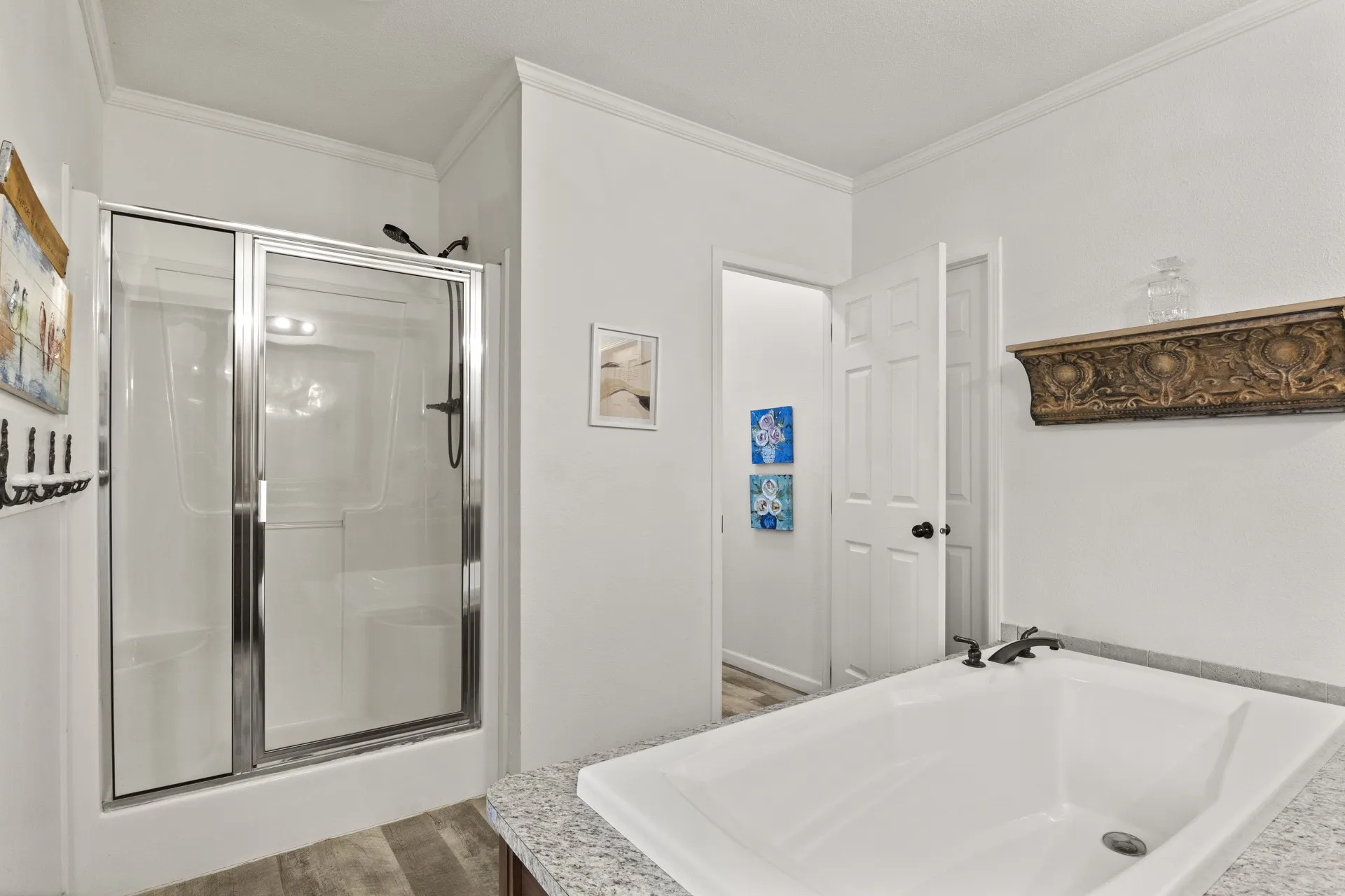 Bathroom featuring ornamental molding, wood-type flooring, and independent shower and bath