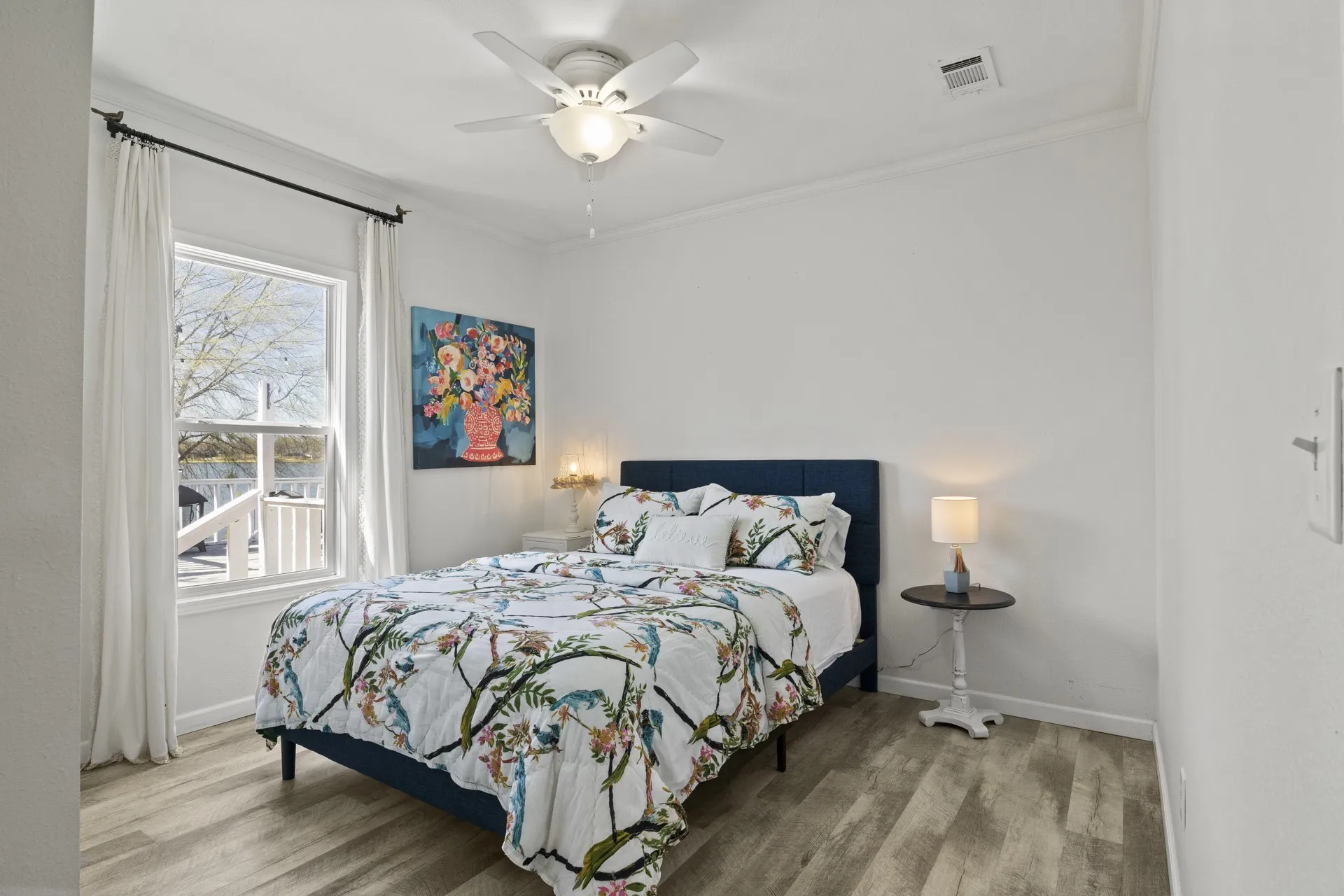 Bedroom with ornamental molding, light hardwood / wood-style flooring, and ceiling fan