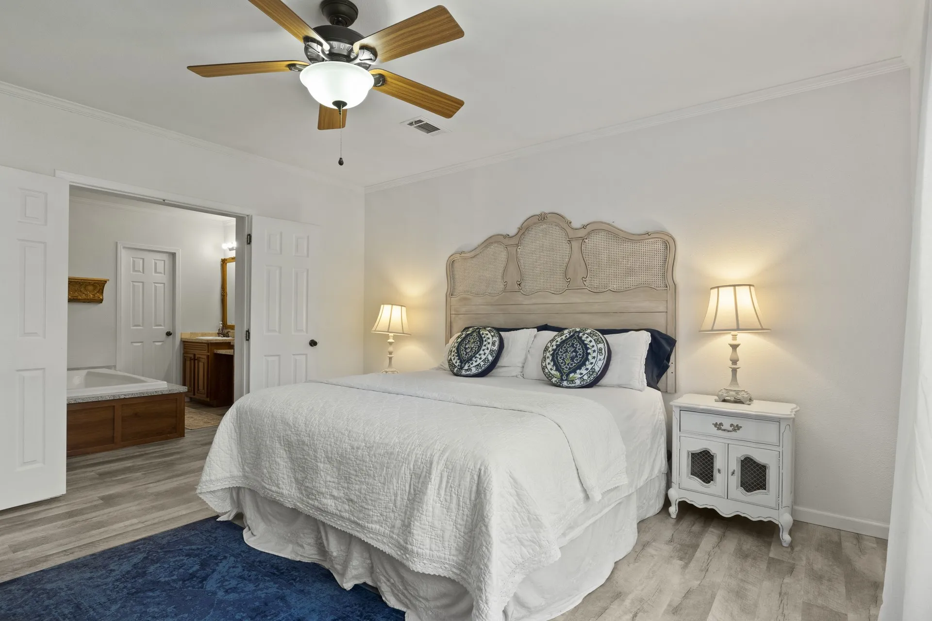 Bedroom featuring ornamental molding, light hardwood / wood-style flooring, and ceiling fan