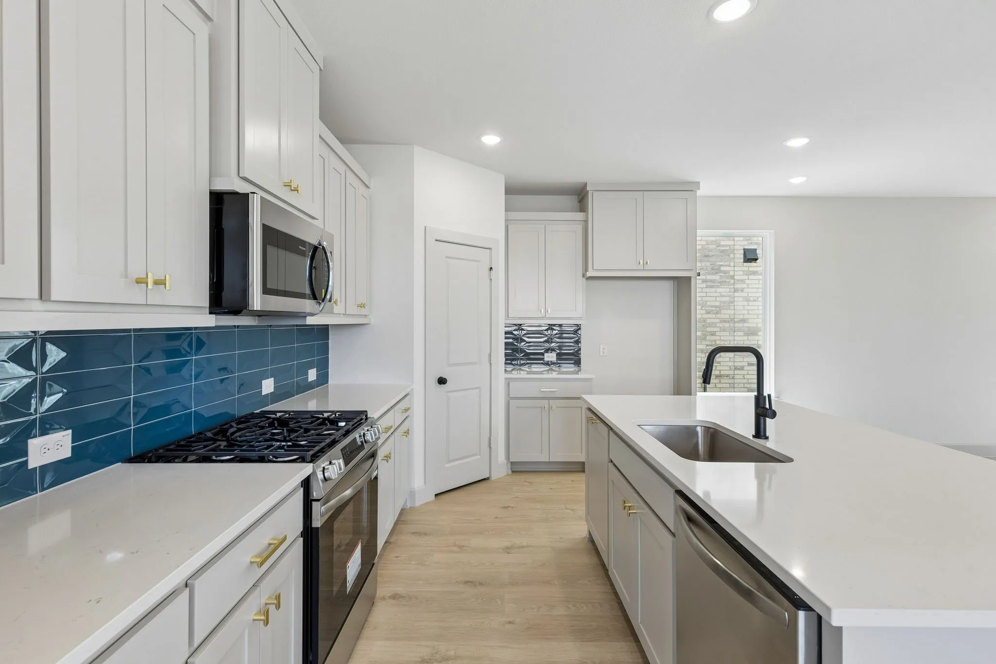 Beautiful cabinetry, gorgeous countertops and a backsplash that provides a POP of color effortlessly blend with contemporary stainless steel to create a kitchen for the ages!