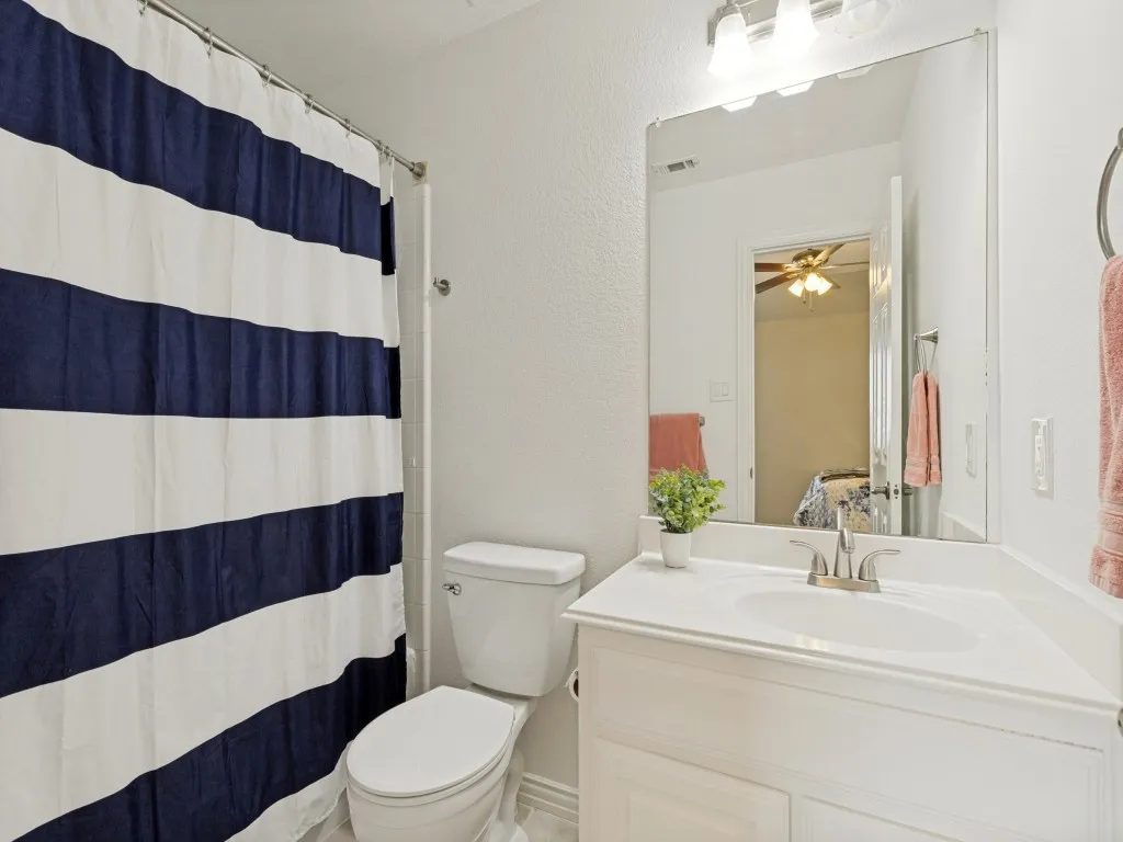 Bathroom with white vanity featuring a built-in sink and brushed nickel faucet