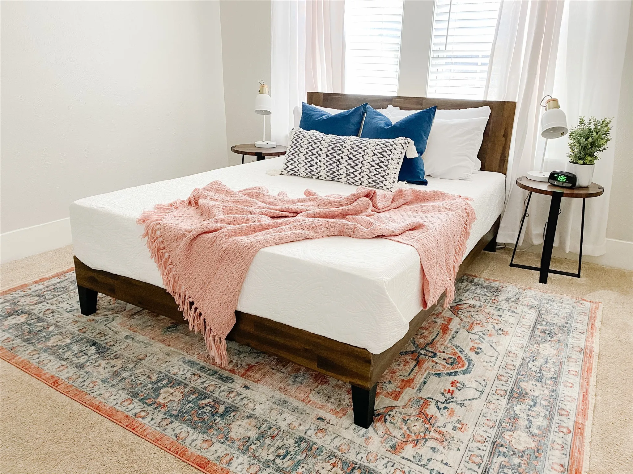 Carpeted bedroom with a window featuring horizontal blinds and sheer drapes