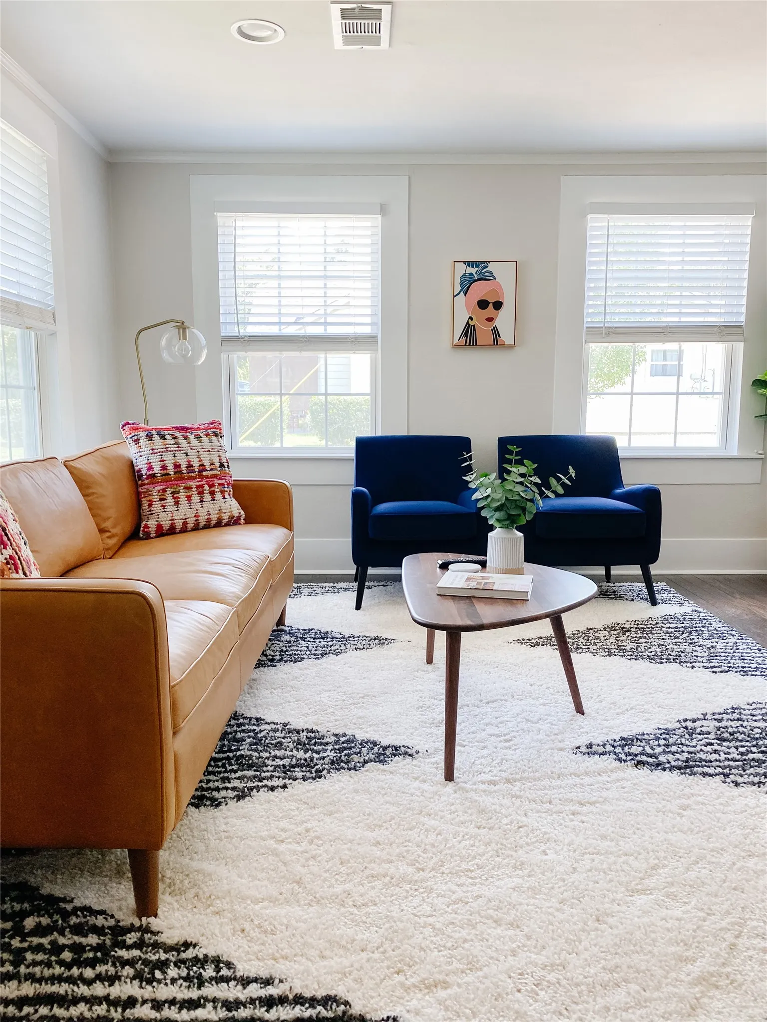 Living area featuring wood-finish flooring, white walls, and crown molding