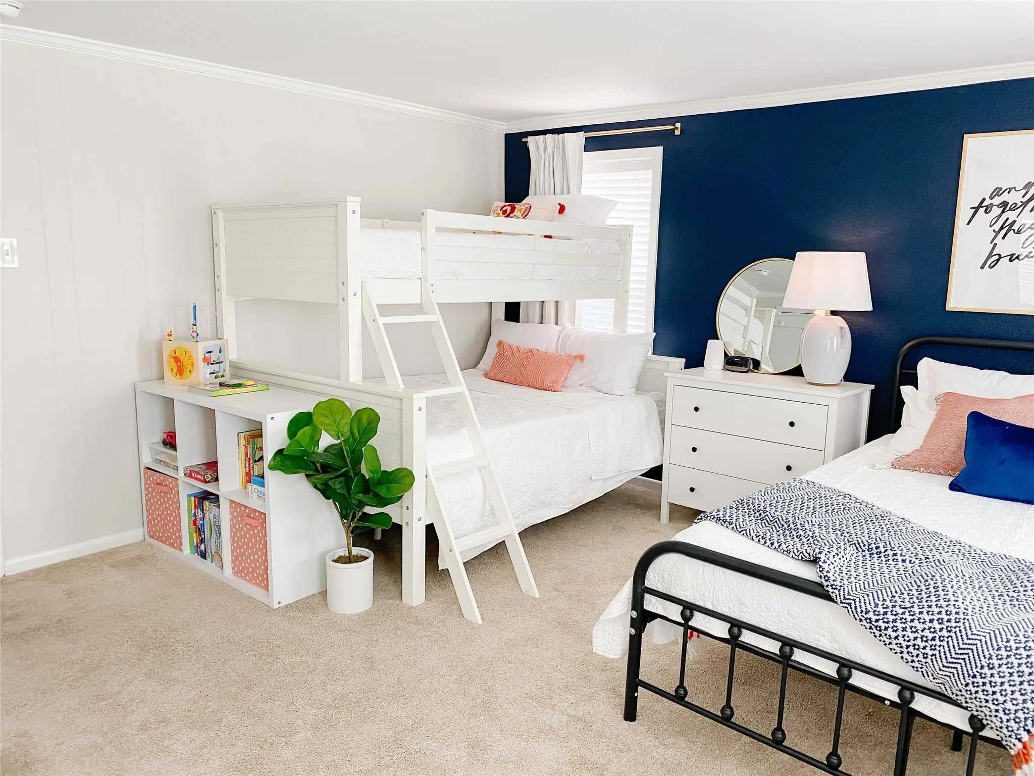 Room featuring neutral carpeting, white wall paneling, crown molding, and a prominent dark blue accent wall