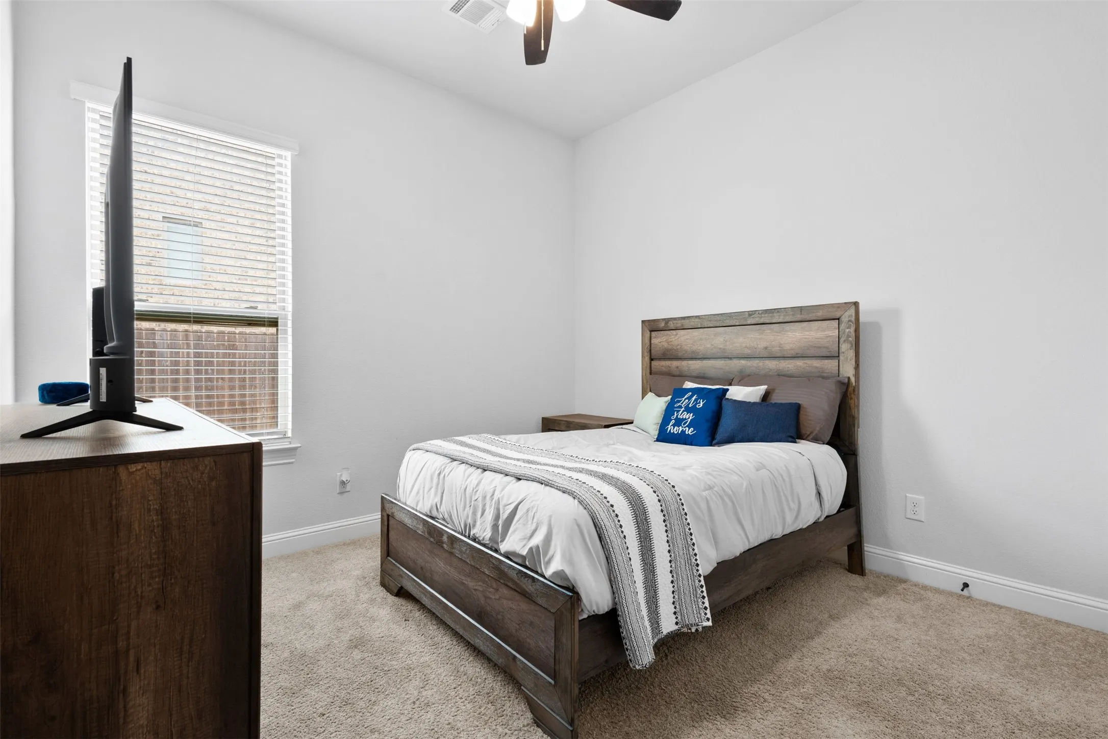 Bedroom featuring light-colored wall paint, carpet flooring, and a ceiling fan with light fixture