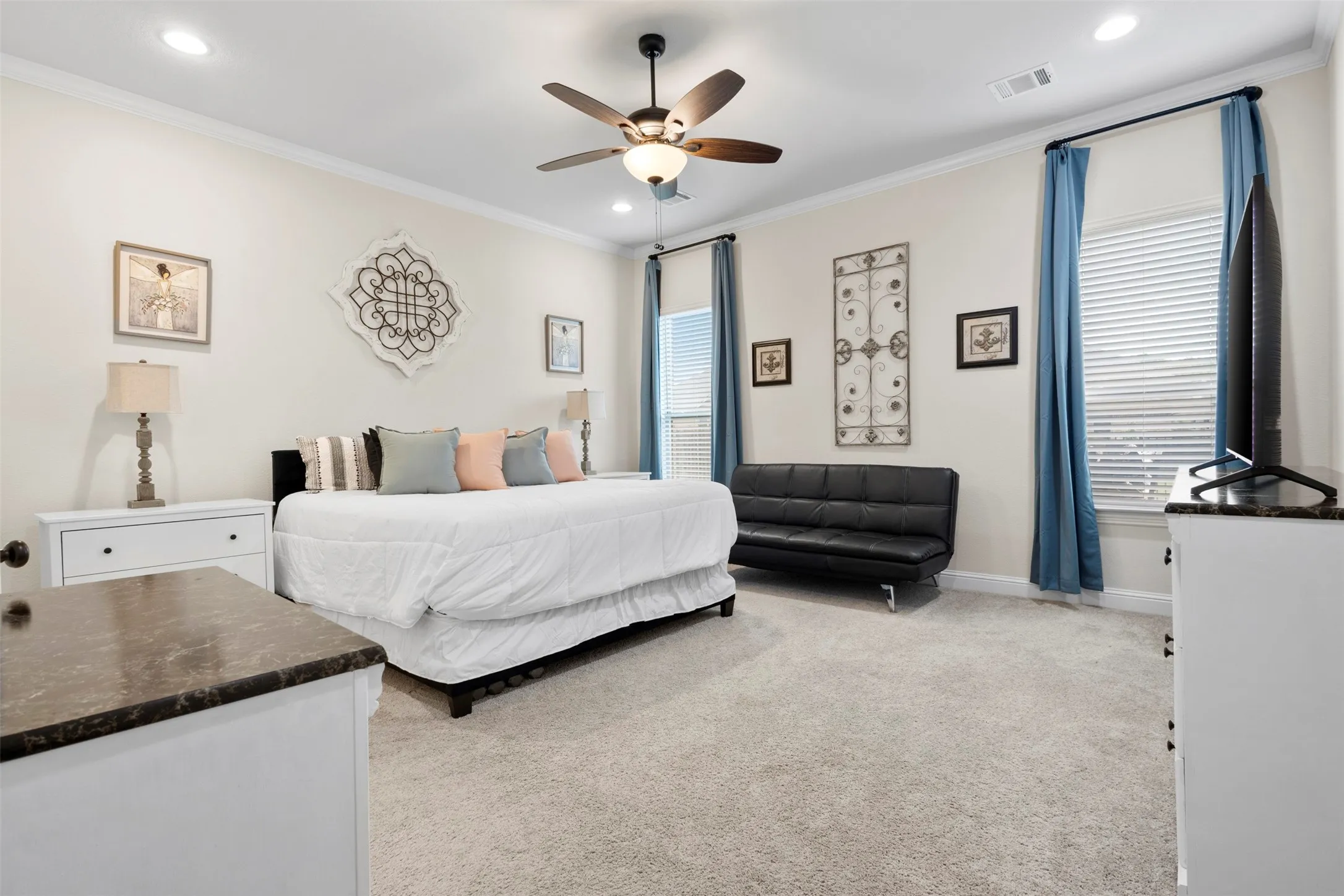 Bright room featuring light-toned carpeting, white walls, and crown molding
