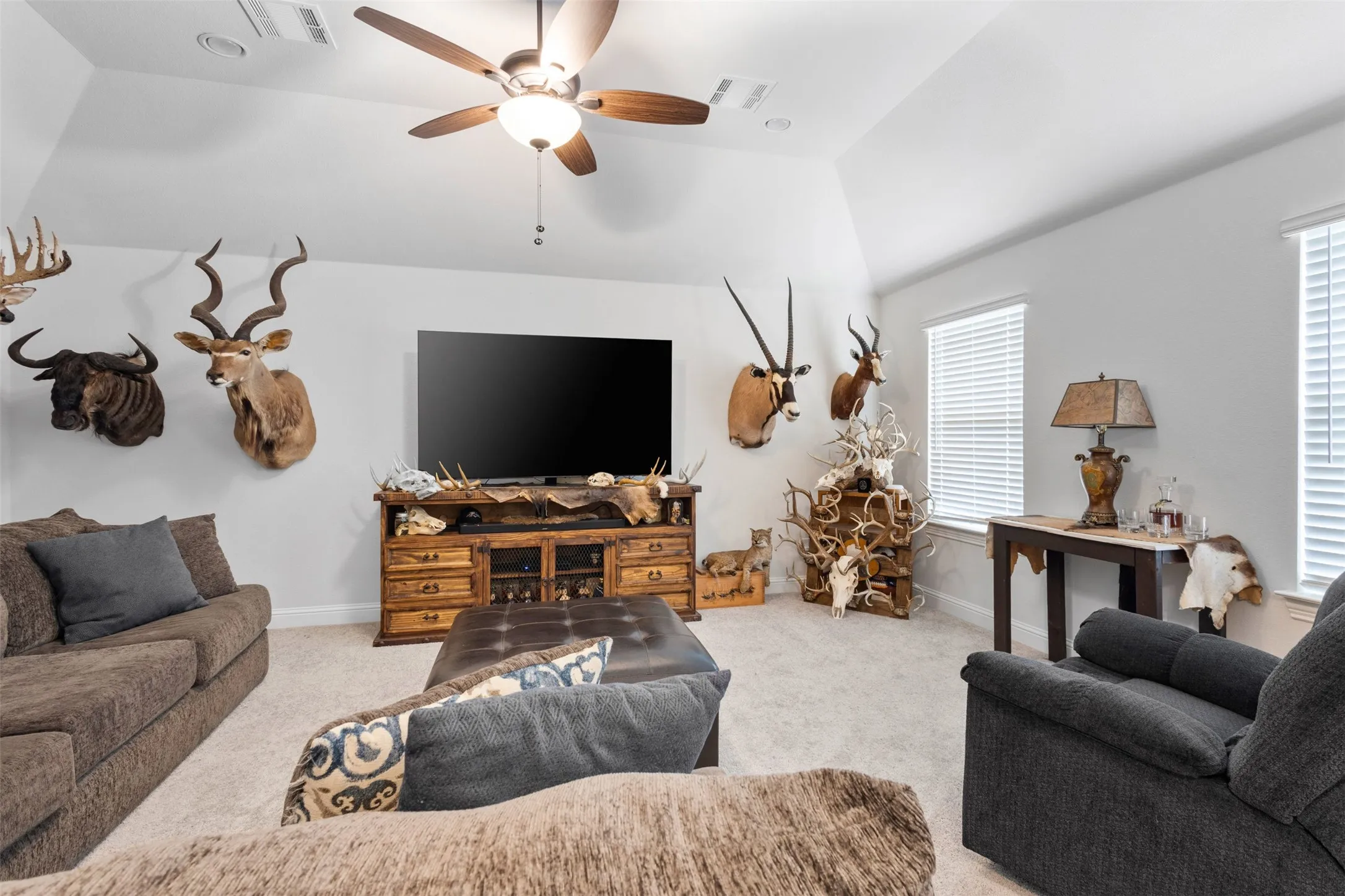 Spacious living area featuring vaulted ceilings and light-colored walls