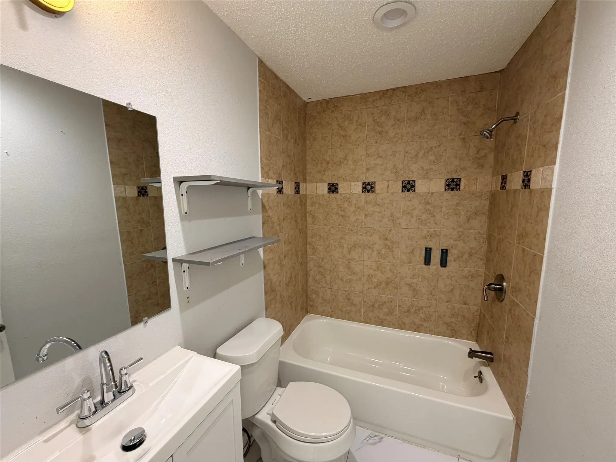 Integrated bathtub with tiled surround and decorative accent band