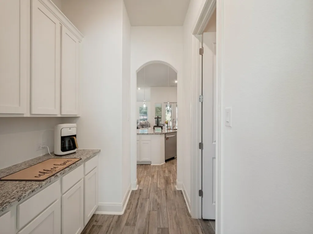 The butler pantry off the kitchen provides additional storage and counterspace and is excellent to use as a coffee bar. Could also serve as a dry bar.  Open doors across the way lead into the huge walk-in pantry.