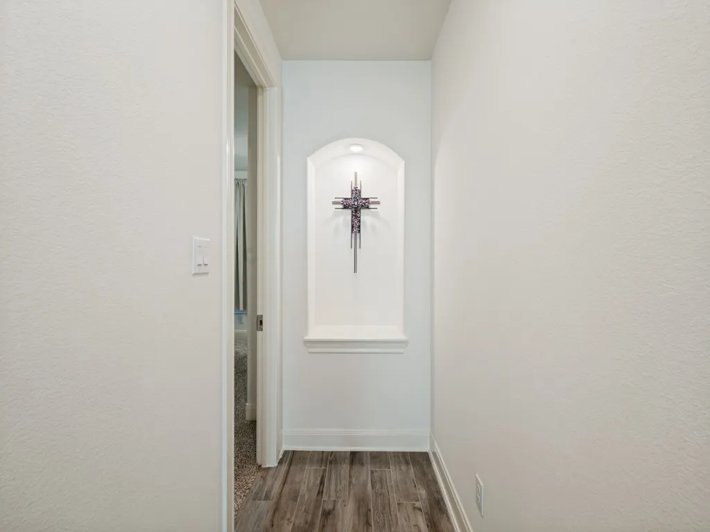 Recessed art niche at the east end of the guest wing adds character and a custom touch to the home's interior. The doorway to the left leads to the second primary suite.
