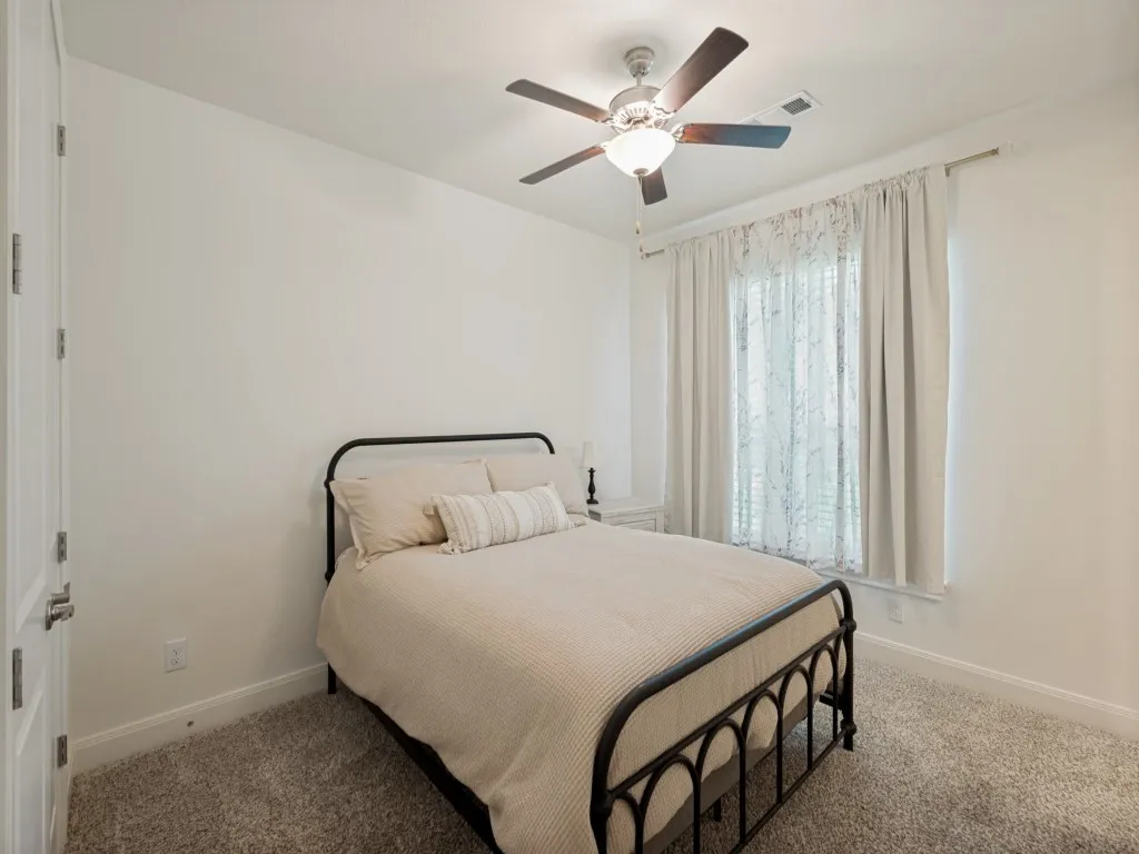 This second primary bedroom has a large closet and an ensuite bathroom offers convenience and privacy for guests. Perfect for a longer-term guest.