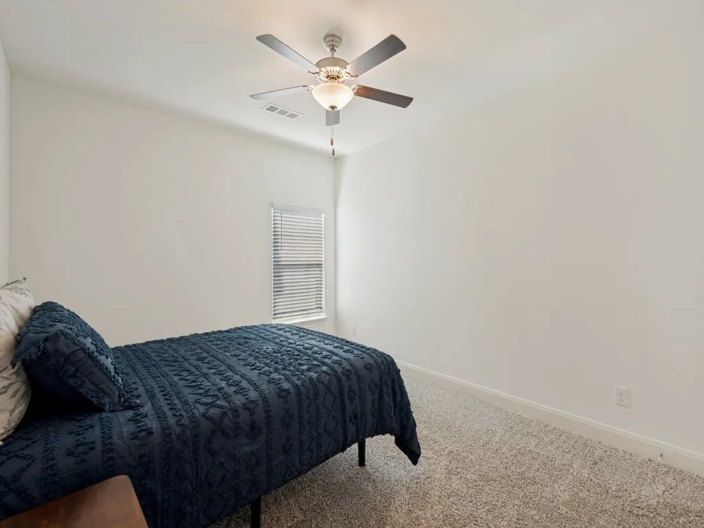 Middle guest room with large closet, ceiling fan, and plenty of natural light.