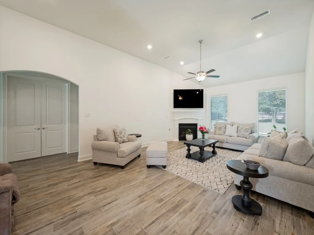 The living room with its corner fireplace provides a welcoming setting for evenings with family and friends.  The double doors to the left lead to a second living area.