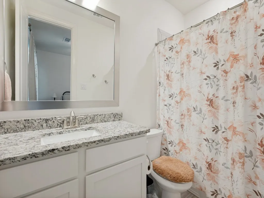 Ensuite bath attached to smaller, second primary suite.