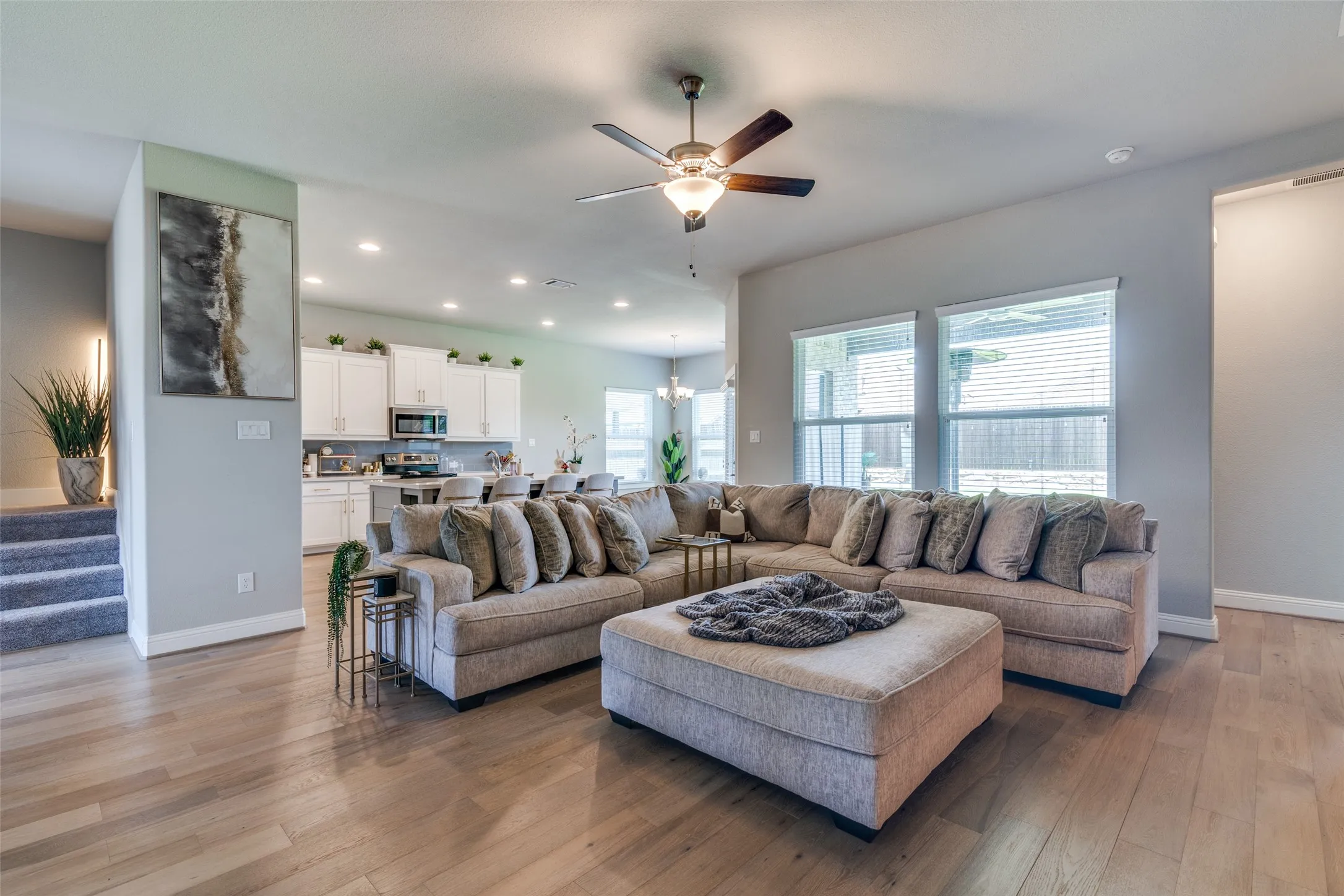 Spacious living area featuring wood-finish flooring, recessed lighting, and a ceiling fan